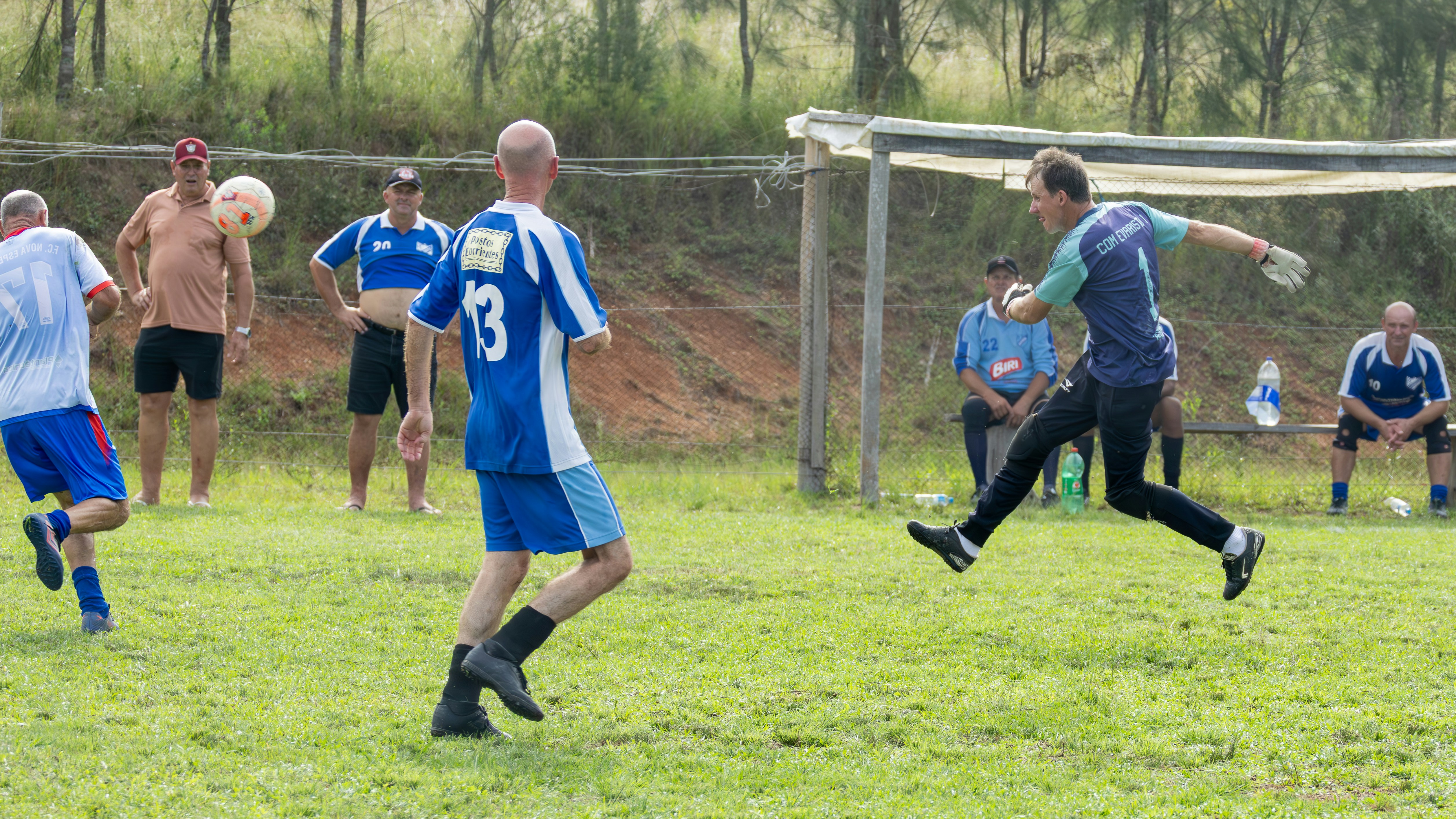 Pria bermain sepak bola di lapangan berumput.