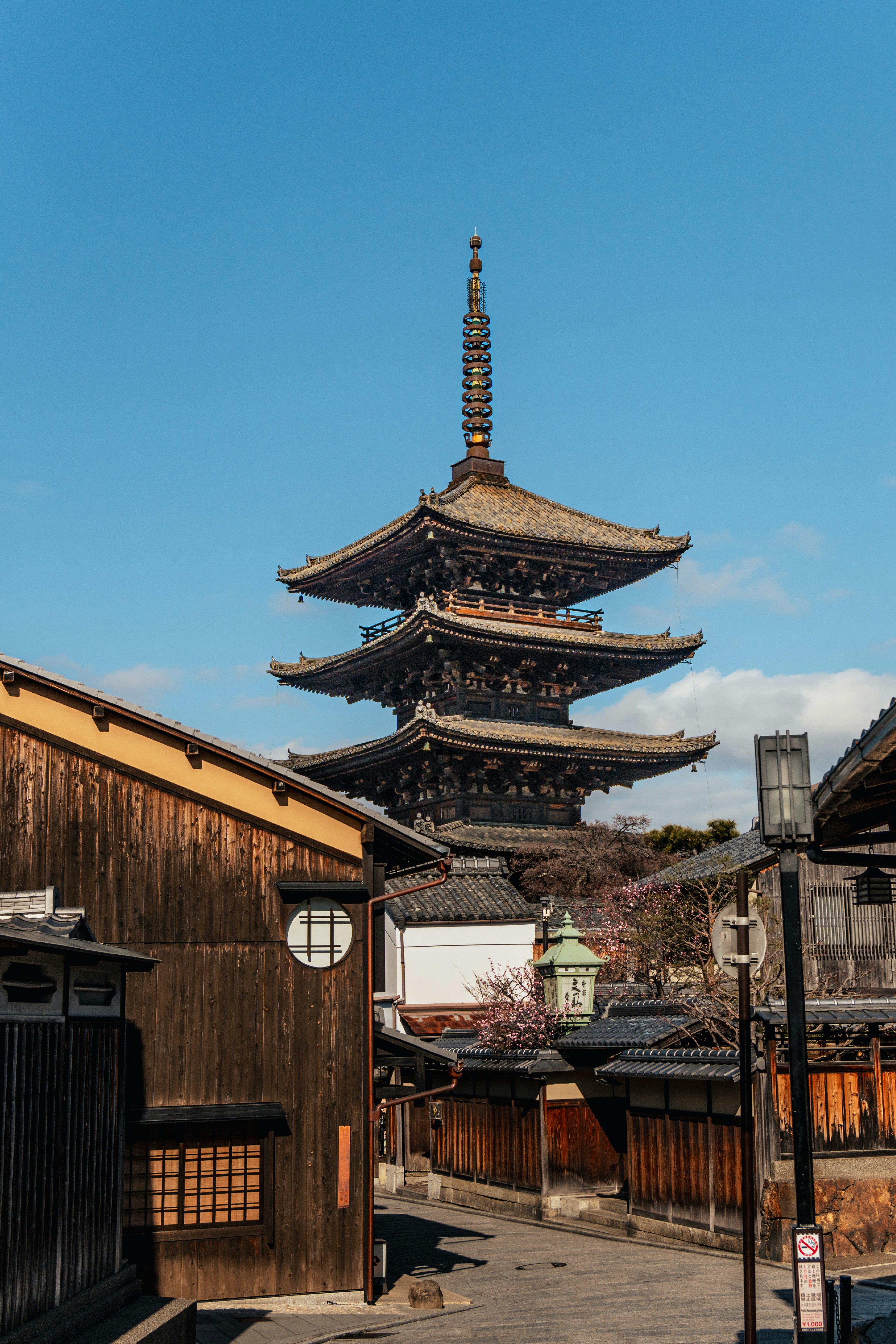 Pagodes japonaises traditionnelles et bâtiments en bois sous un ciel bleu.
