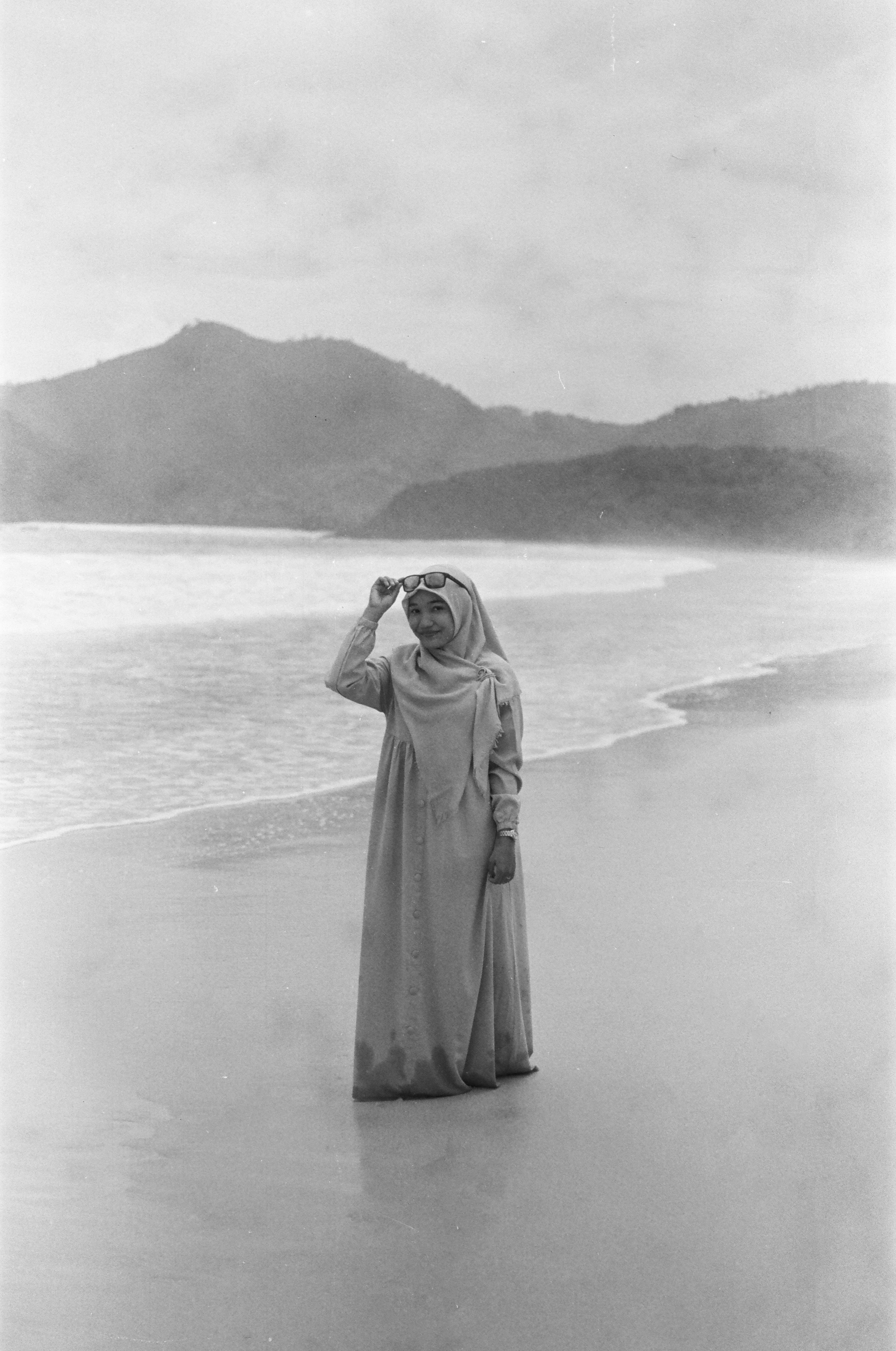 Mulher de hijab em pé na praia