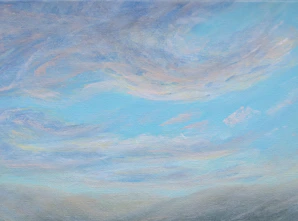 Wispy clouds drift across a pale blue sky.