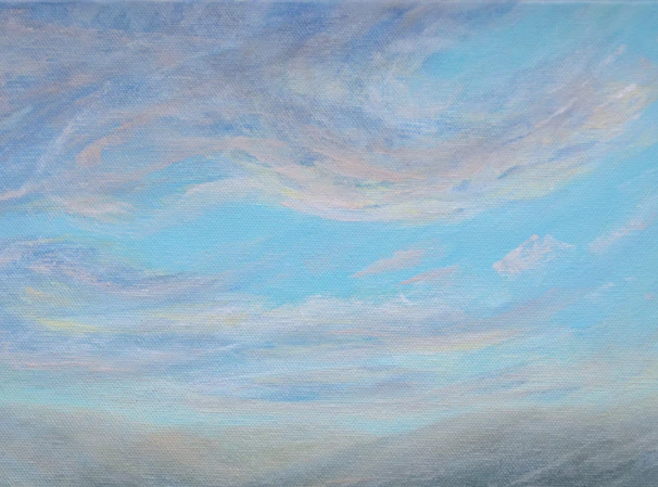 Wispy clouds drift across a pale blue sky.