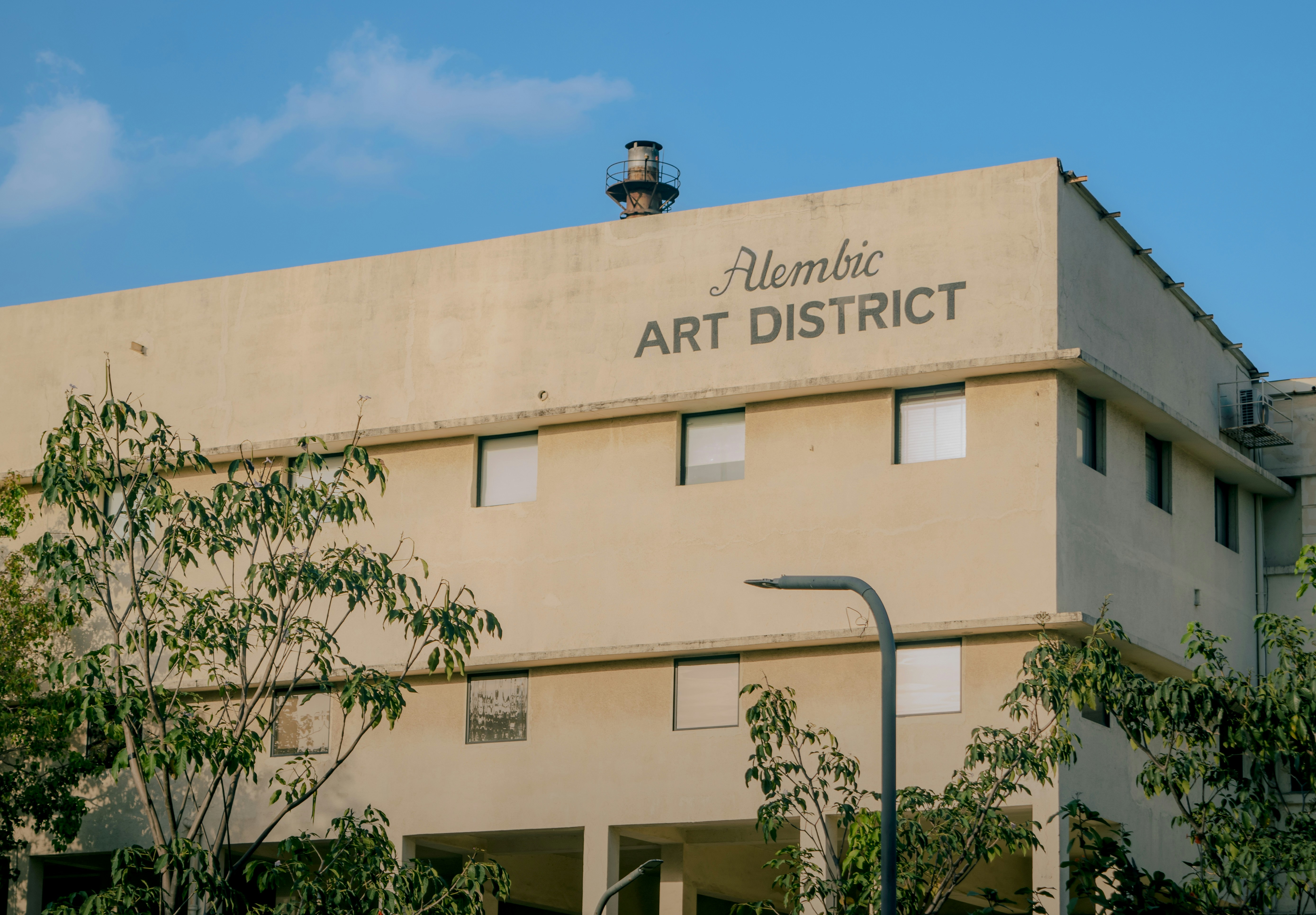 Alembic art district building with trees and sky.