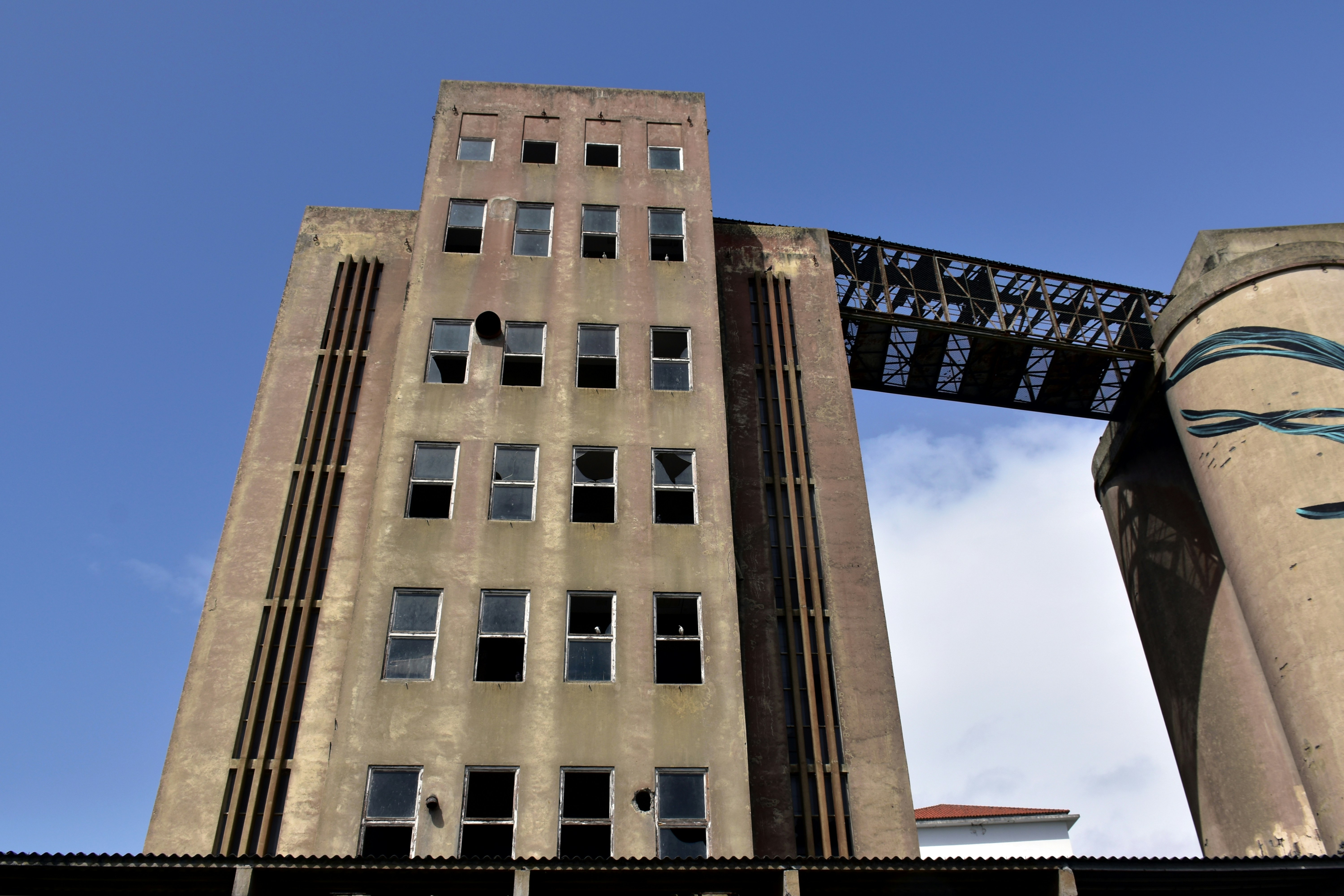 Tall concrete industrial building with broken windows