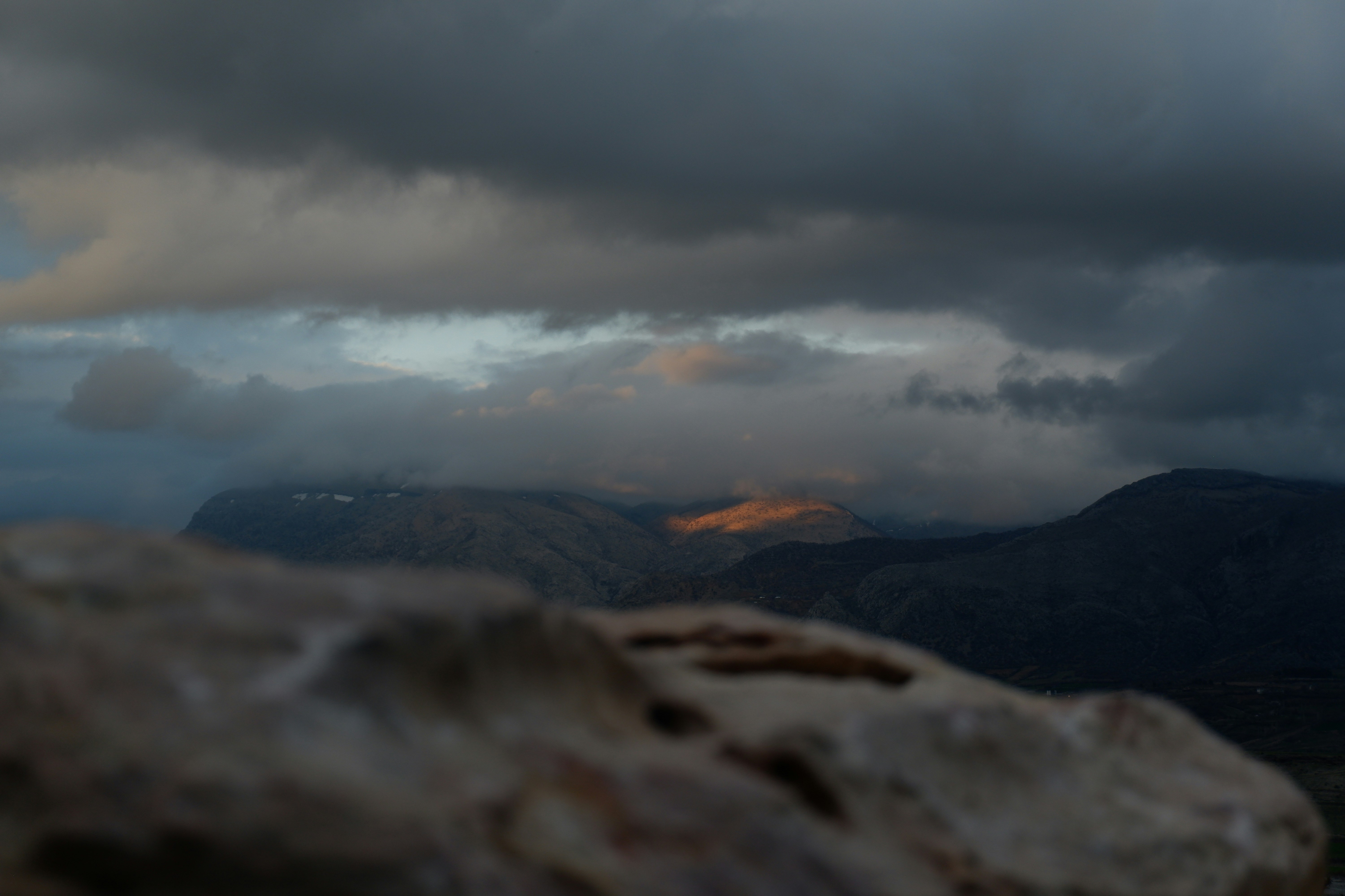 Dramatic clouds over a sunlit mountain valley