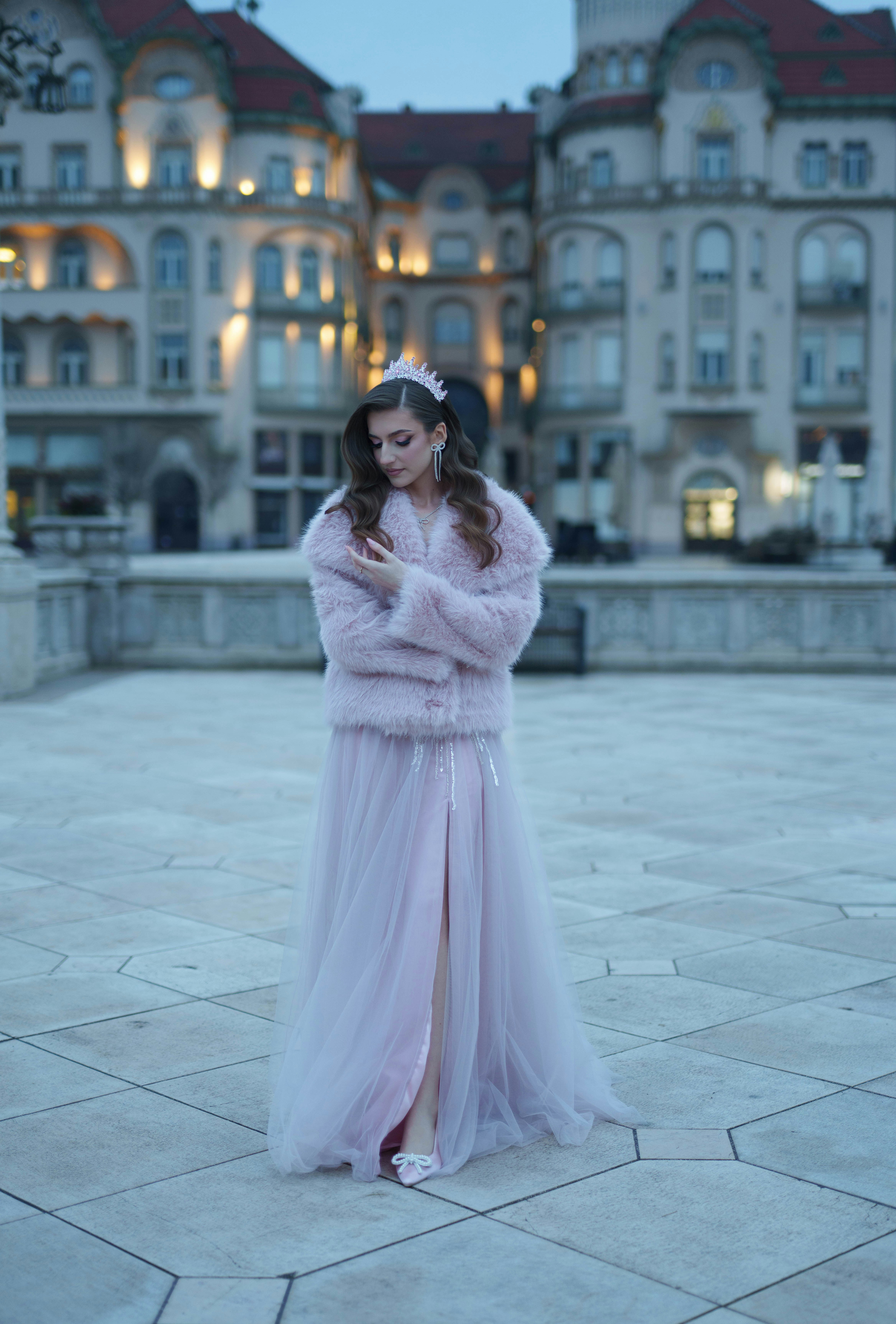 Mulher com elegante vestido rosa e casaco de pele ao ar livre