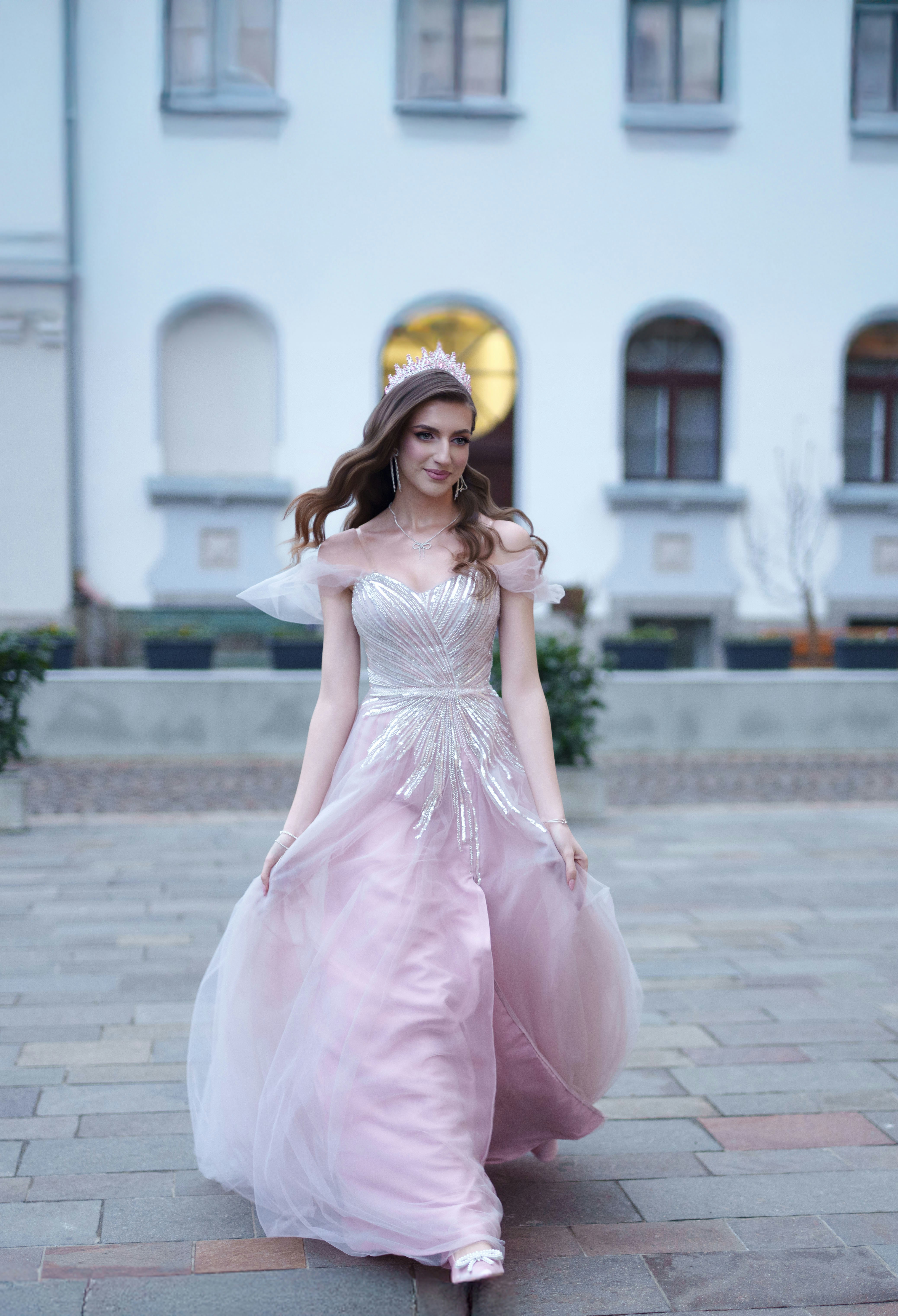 Jovem mulher em vestido de baile rosa usando uma tiara