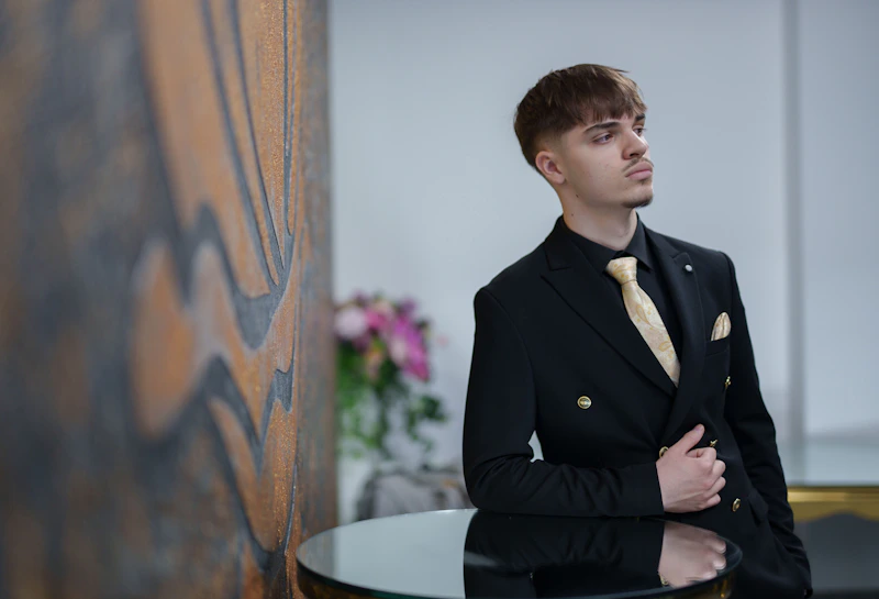 elegant man in a black suit and gold tie