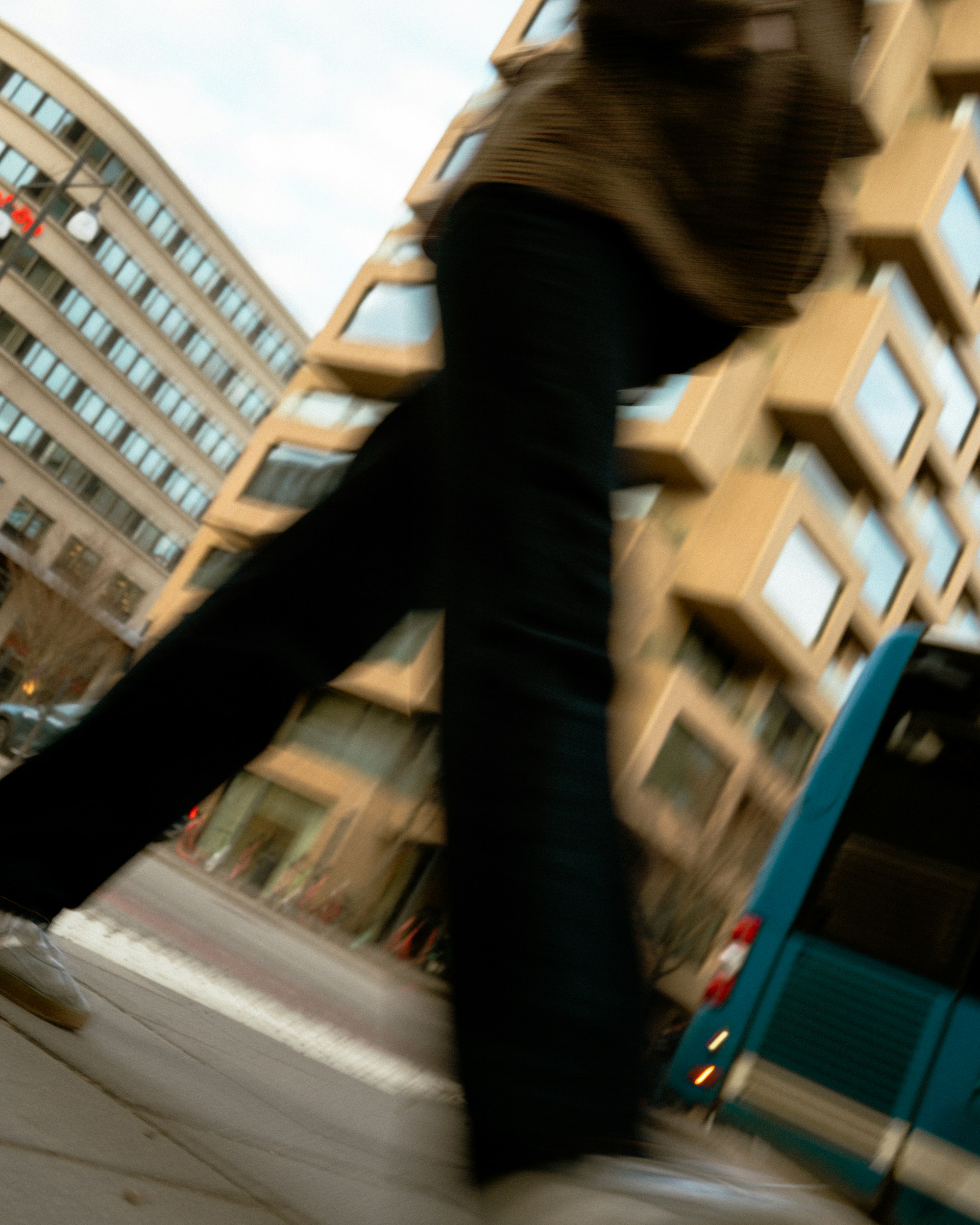 Person walking past a bus on a city street.