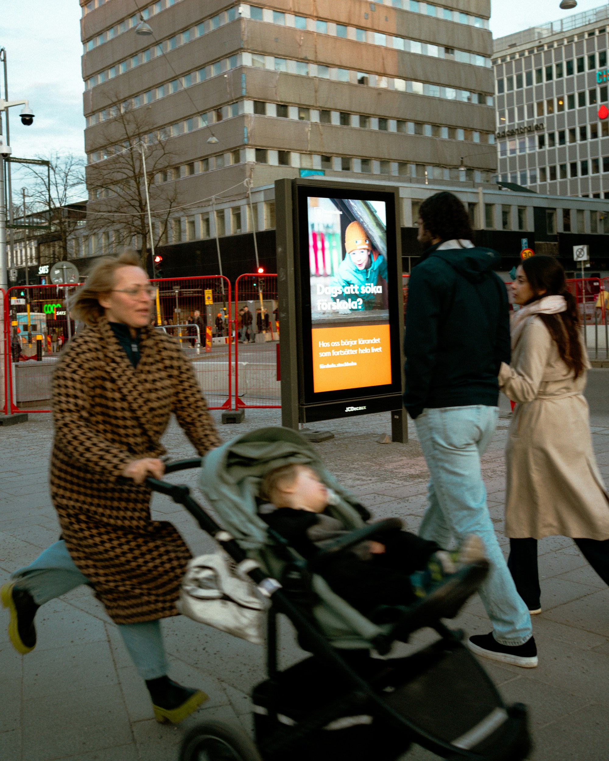 Woman pushing stroller with child on city street