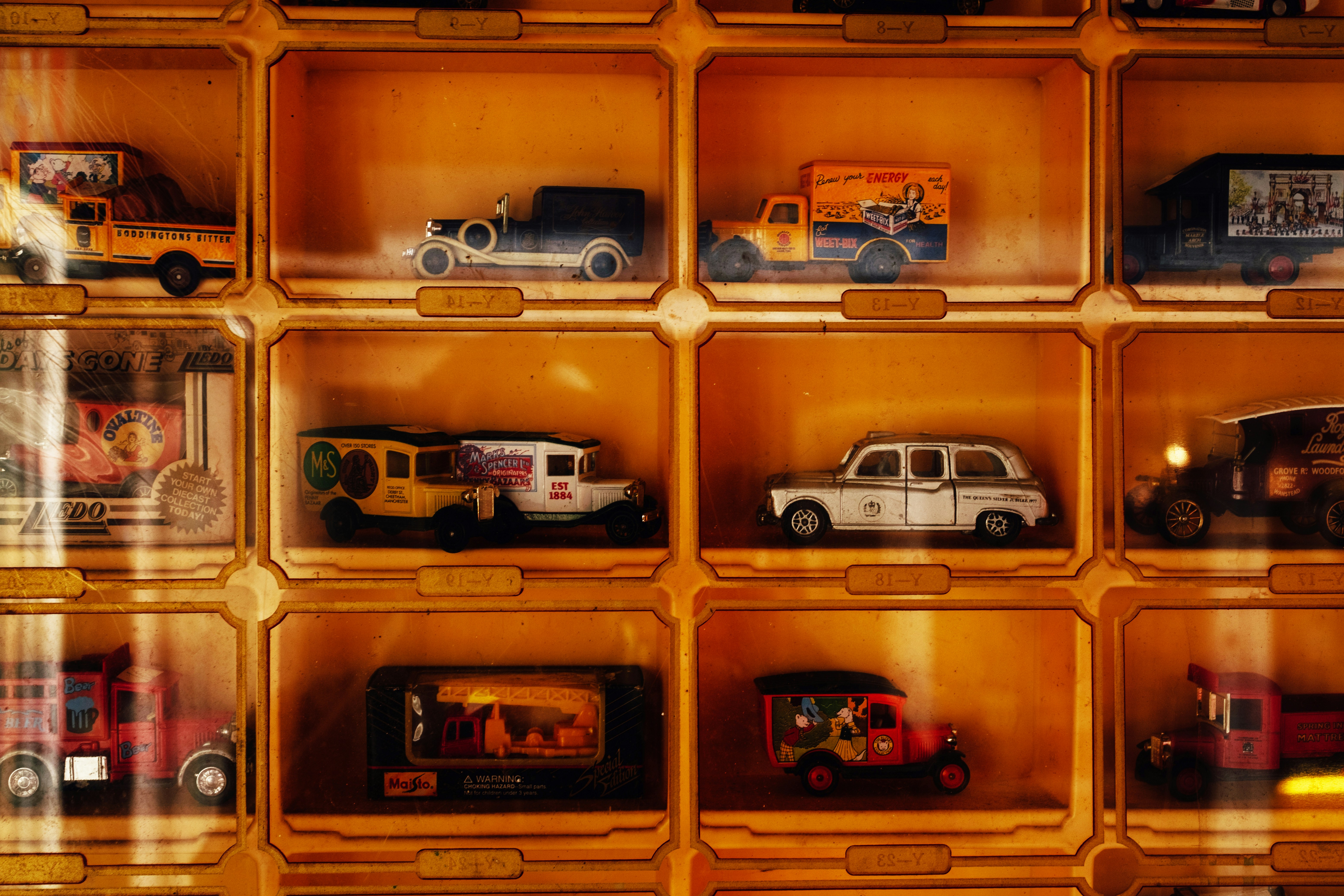 Collection of vintage toy cars displayed in wooden cubbies.