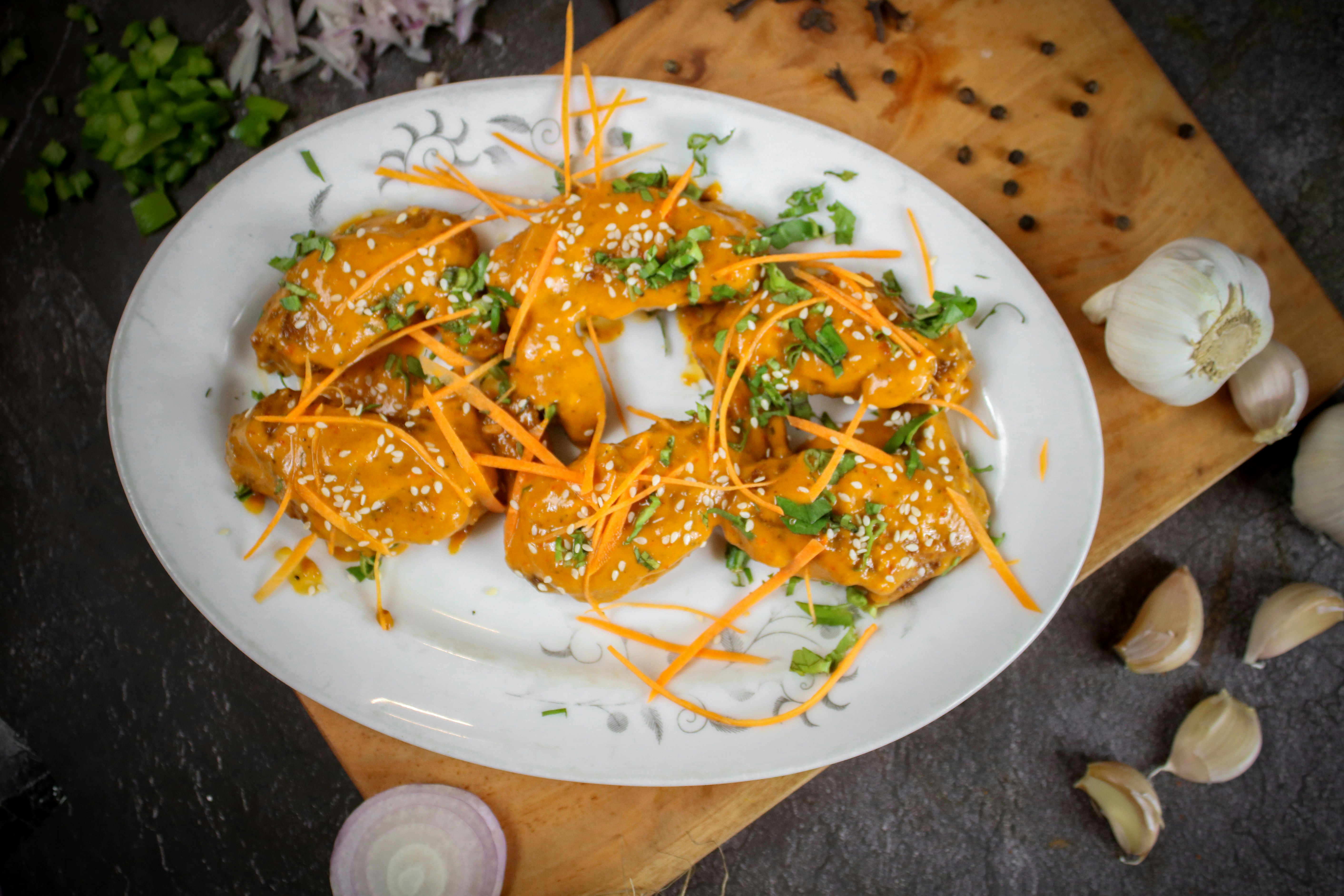 Plate of food with sauce, carrots, and herbs