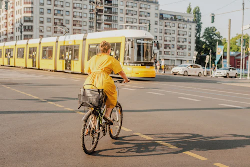 A woman cycling past a yellow tram on a city street, showing how everyday travel decides what counts as nearby