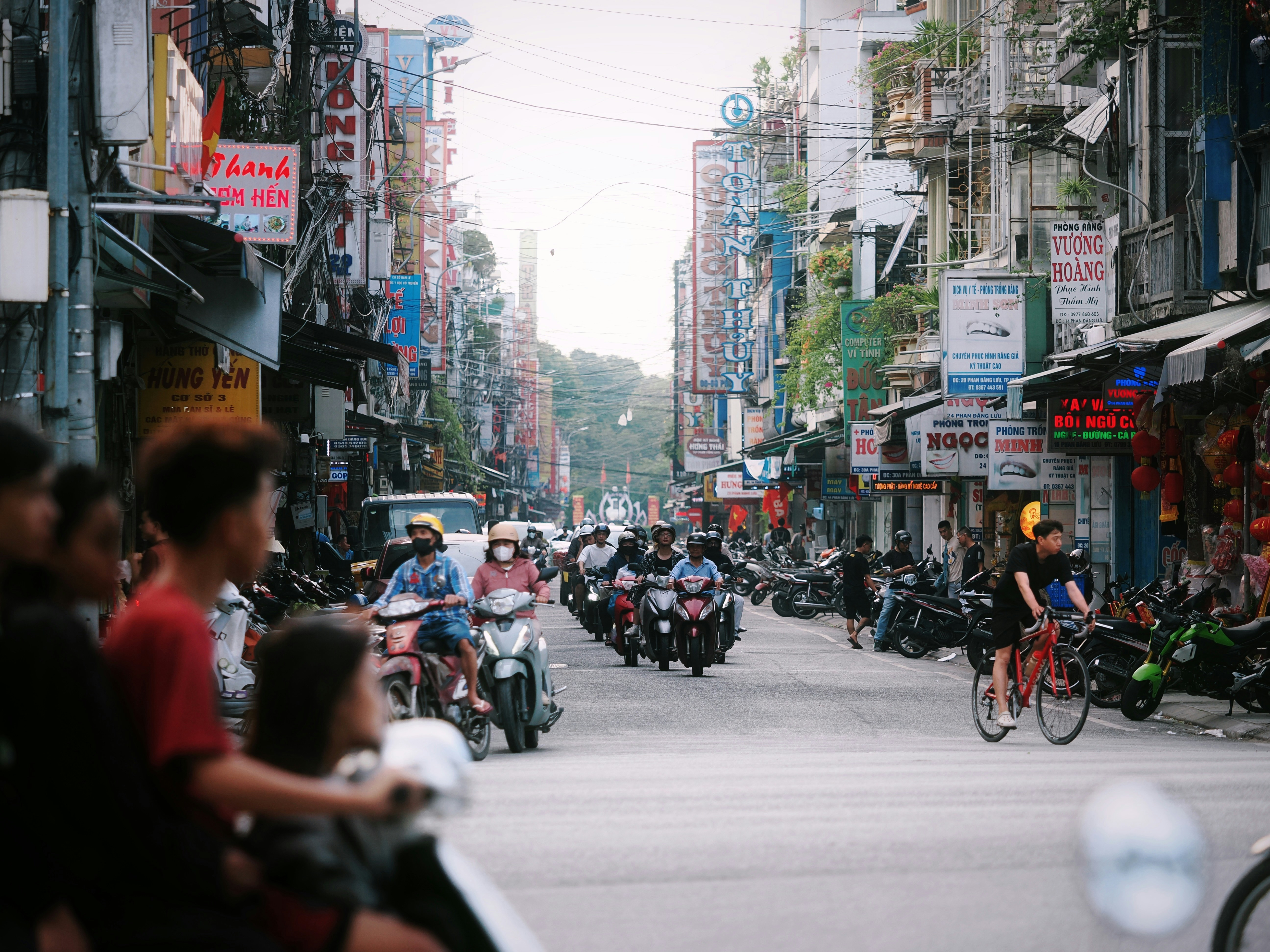 Busy street scene with motorcycles and buildings