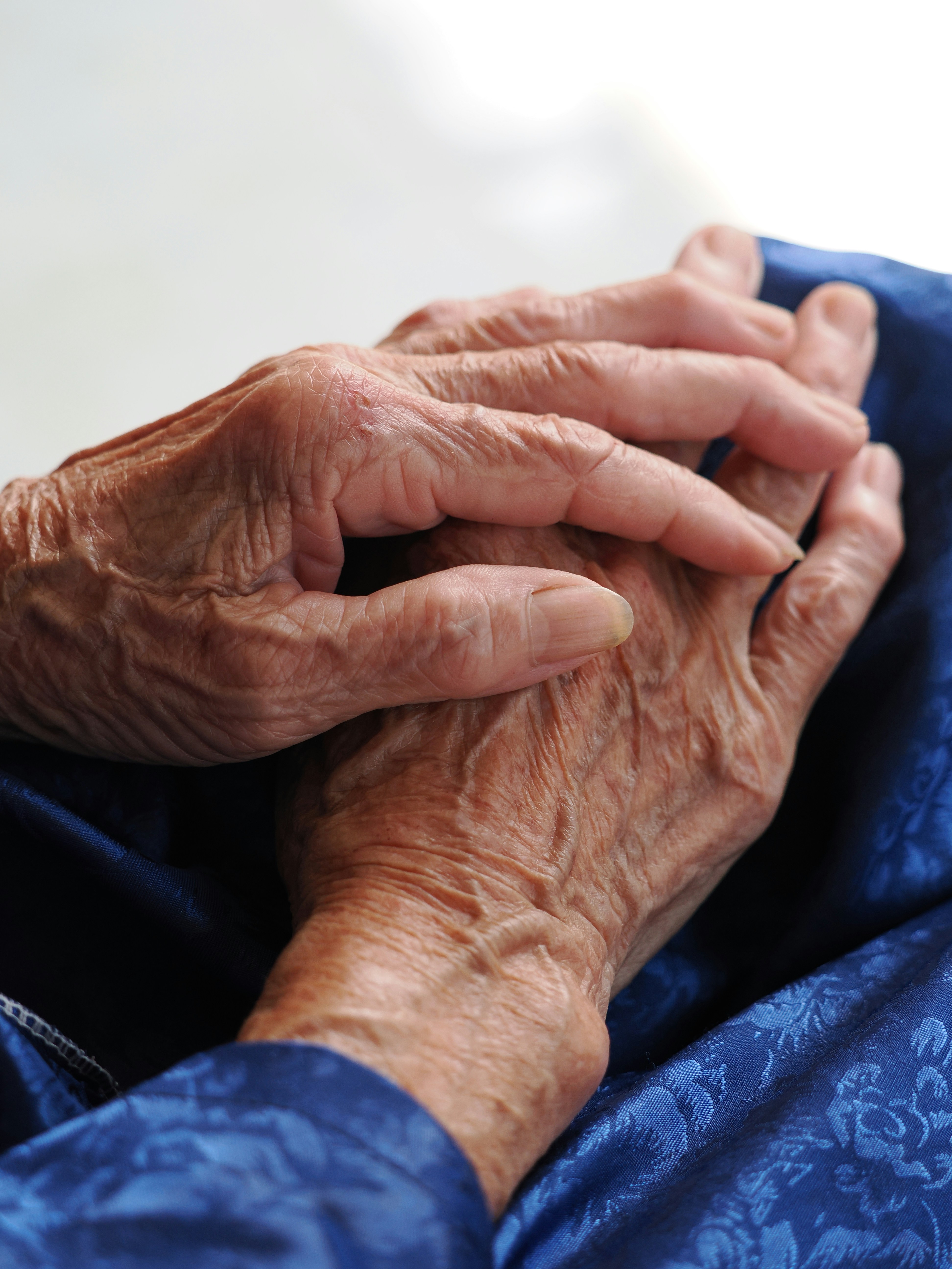 Manos arrugadas de una persona mayor descansando