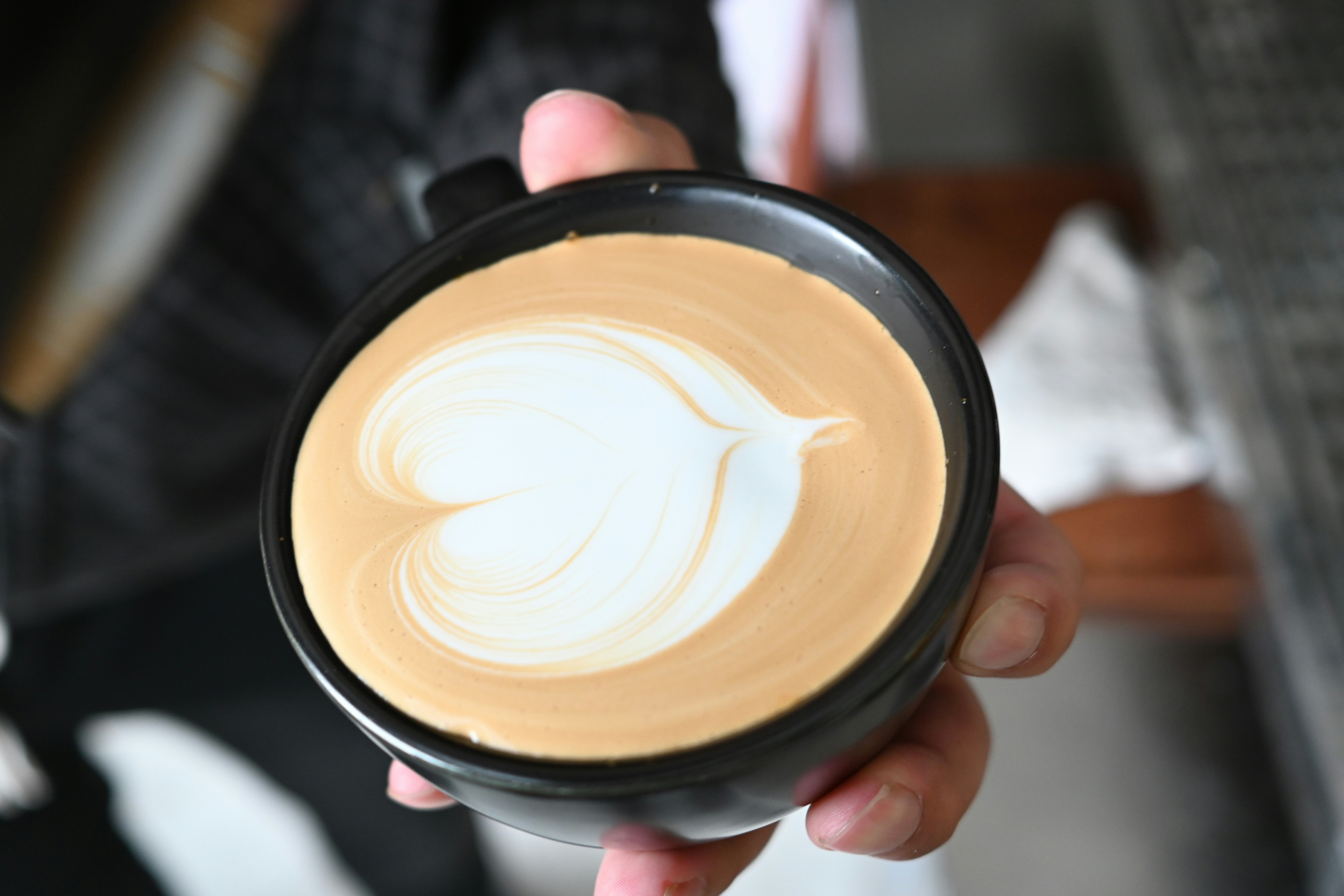 Close-up of creamy latte art in a black mug