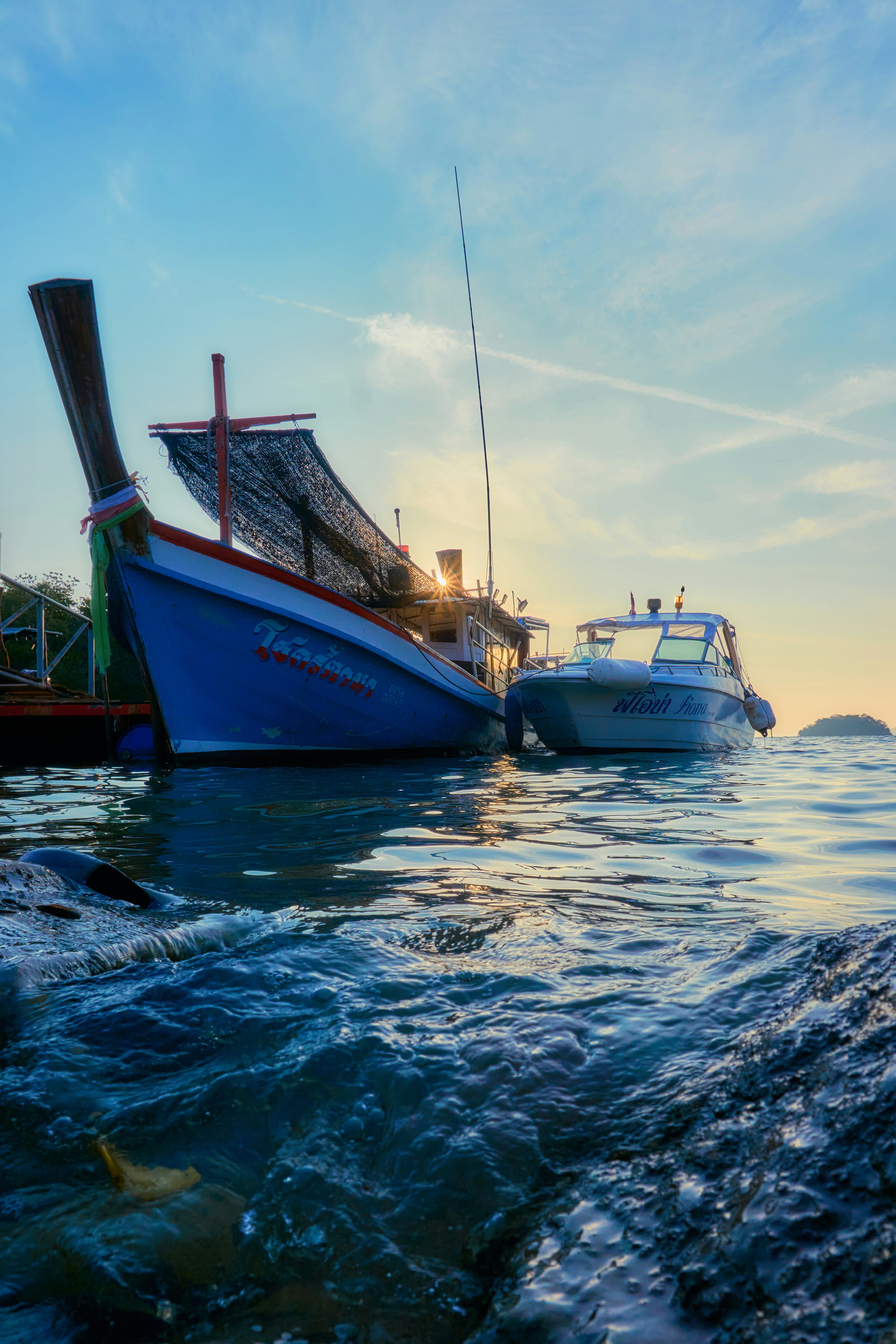 Zwei Boote lagen bei Sonnenuntergang im Ozean fest
