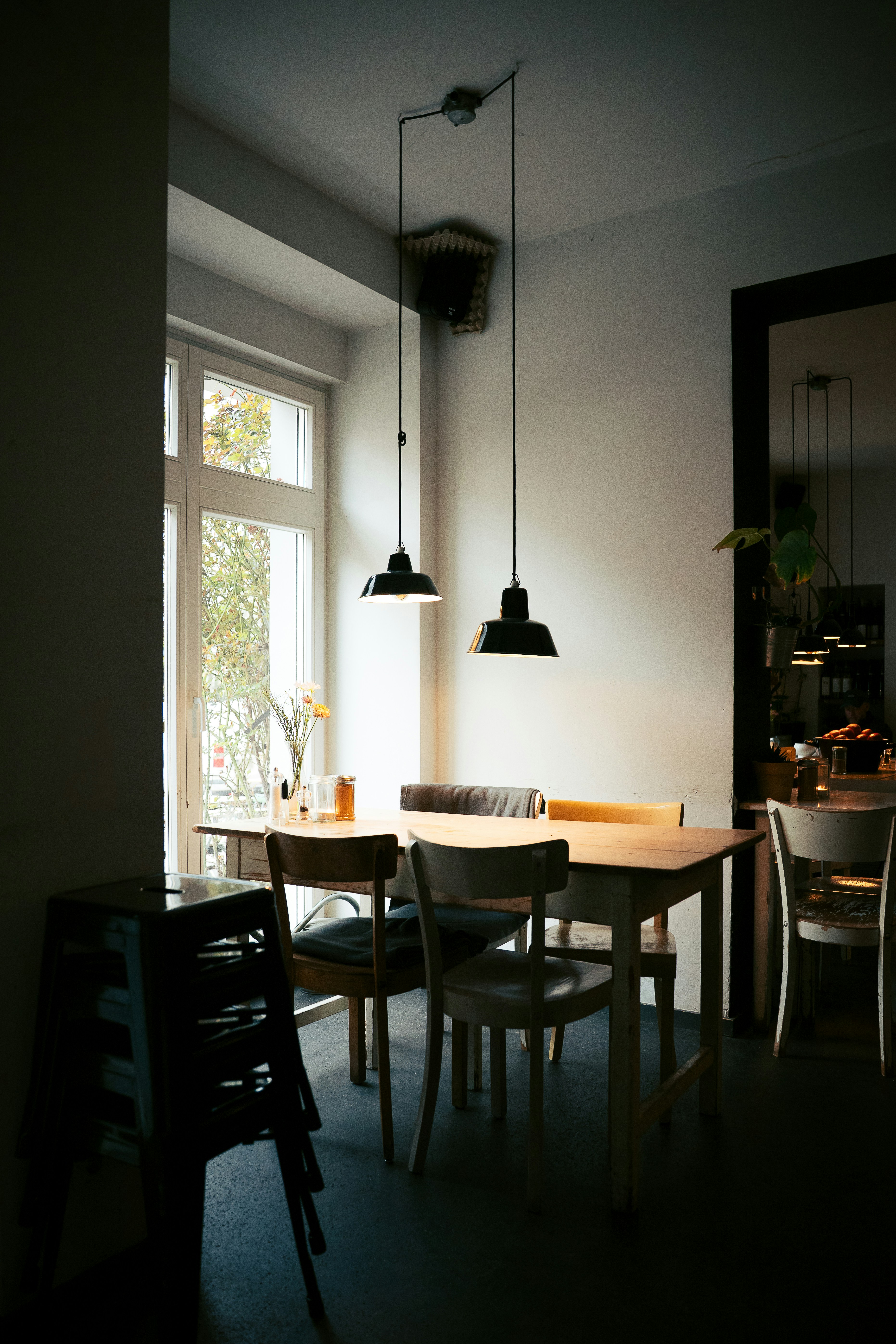Cafe interior with tables and chairs near window.