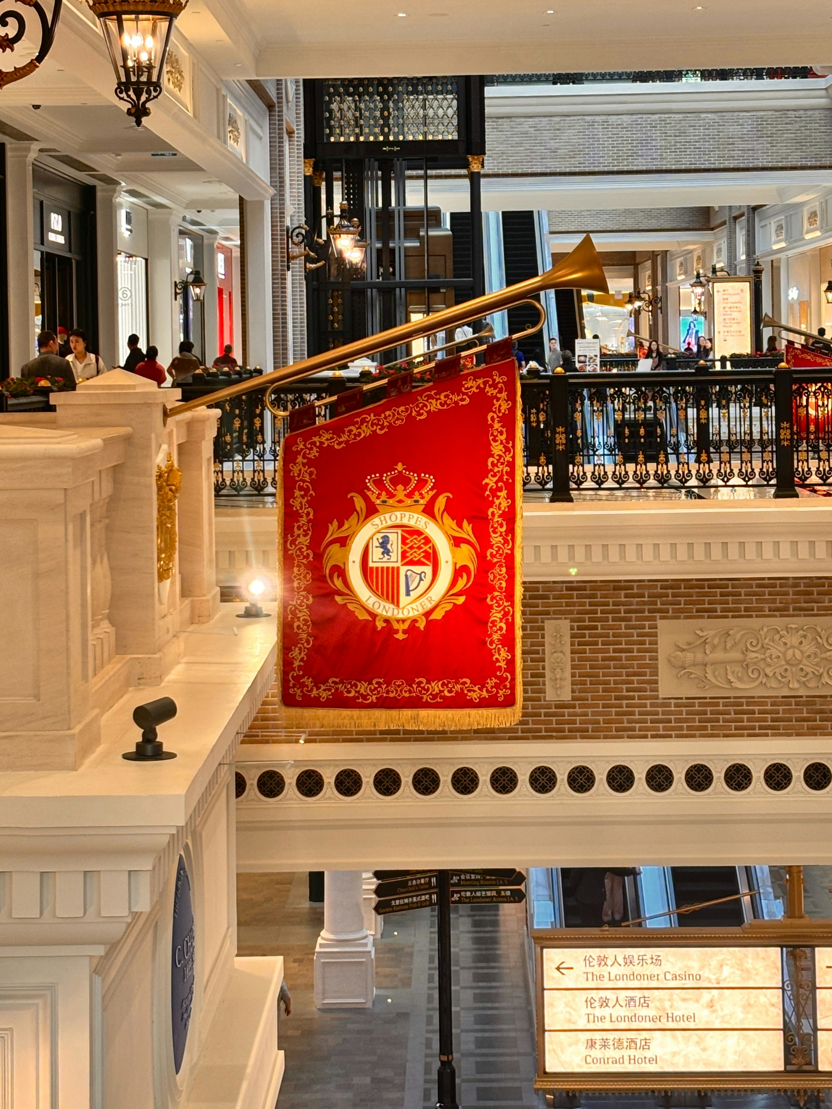 Ein rotes Banner mit Wappen hängt in einem Gebäude.