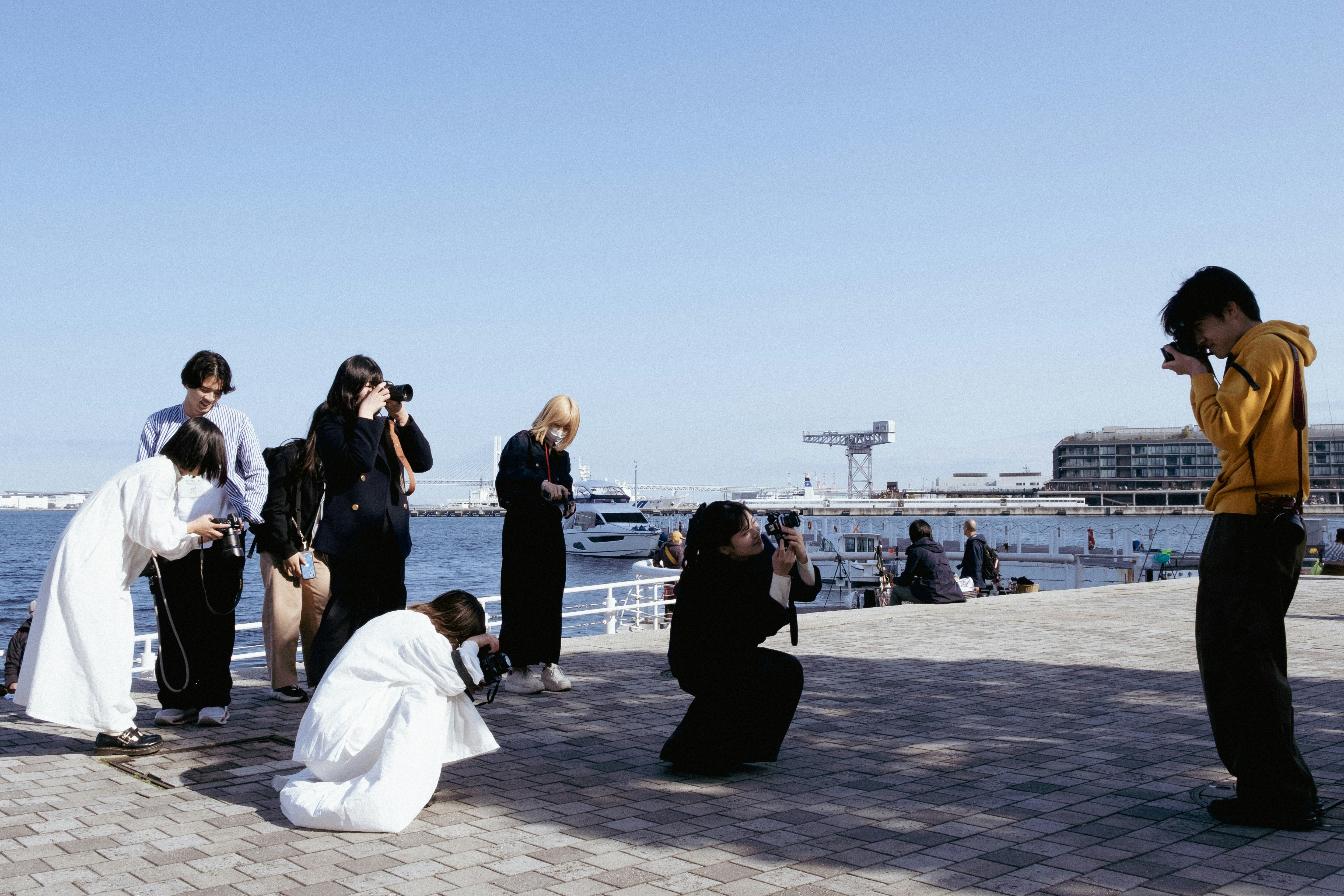 People taking photos by the water on a sunny day