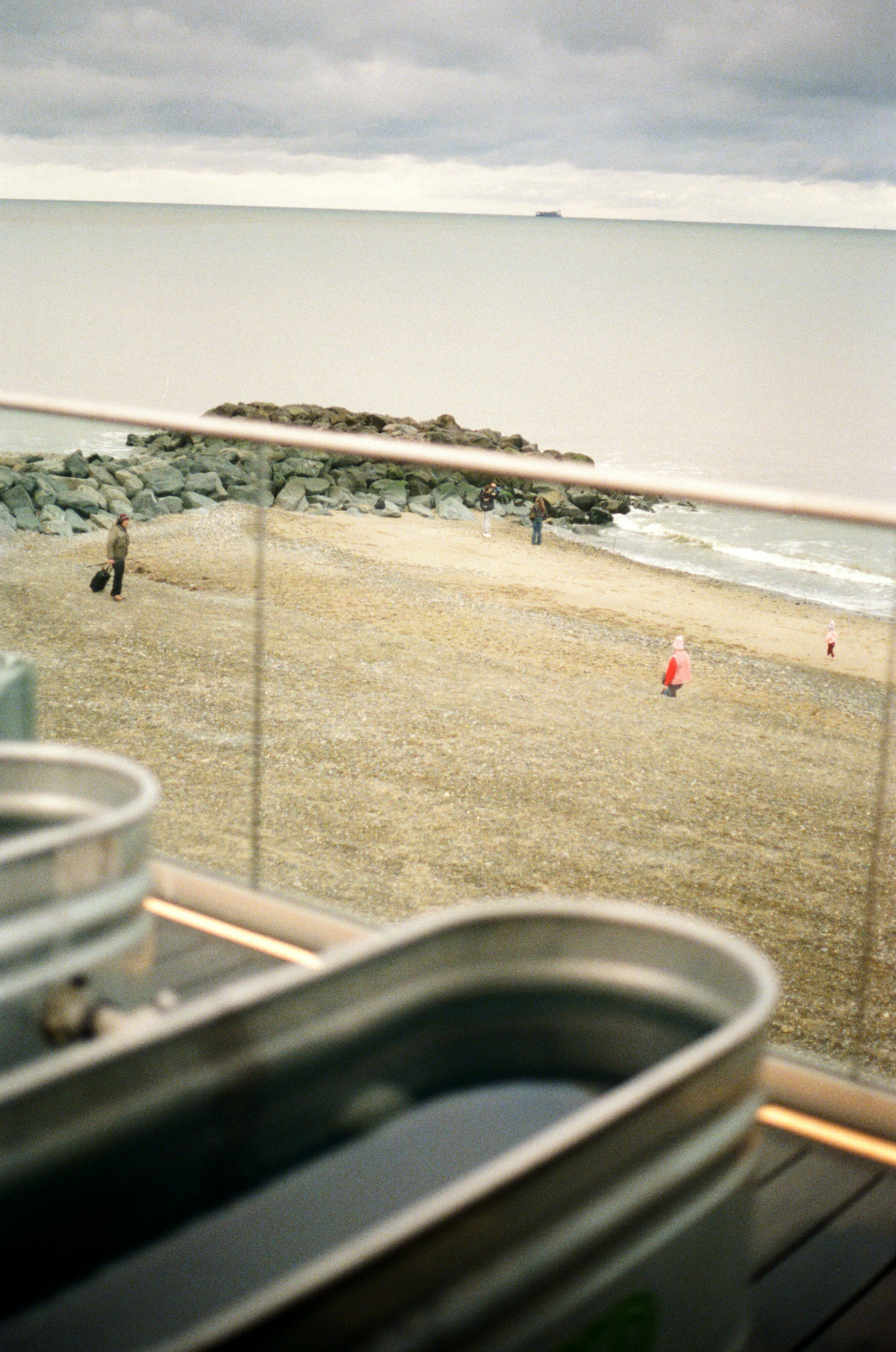 People on a sandy beach with a calm ocean background.