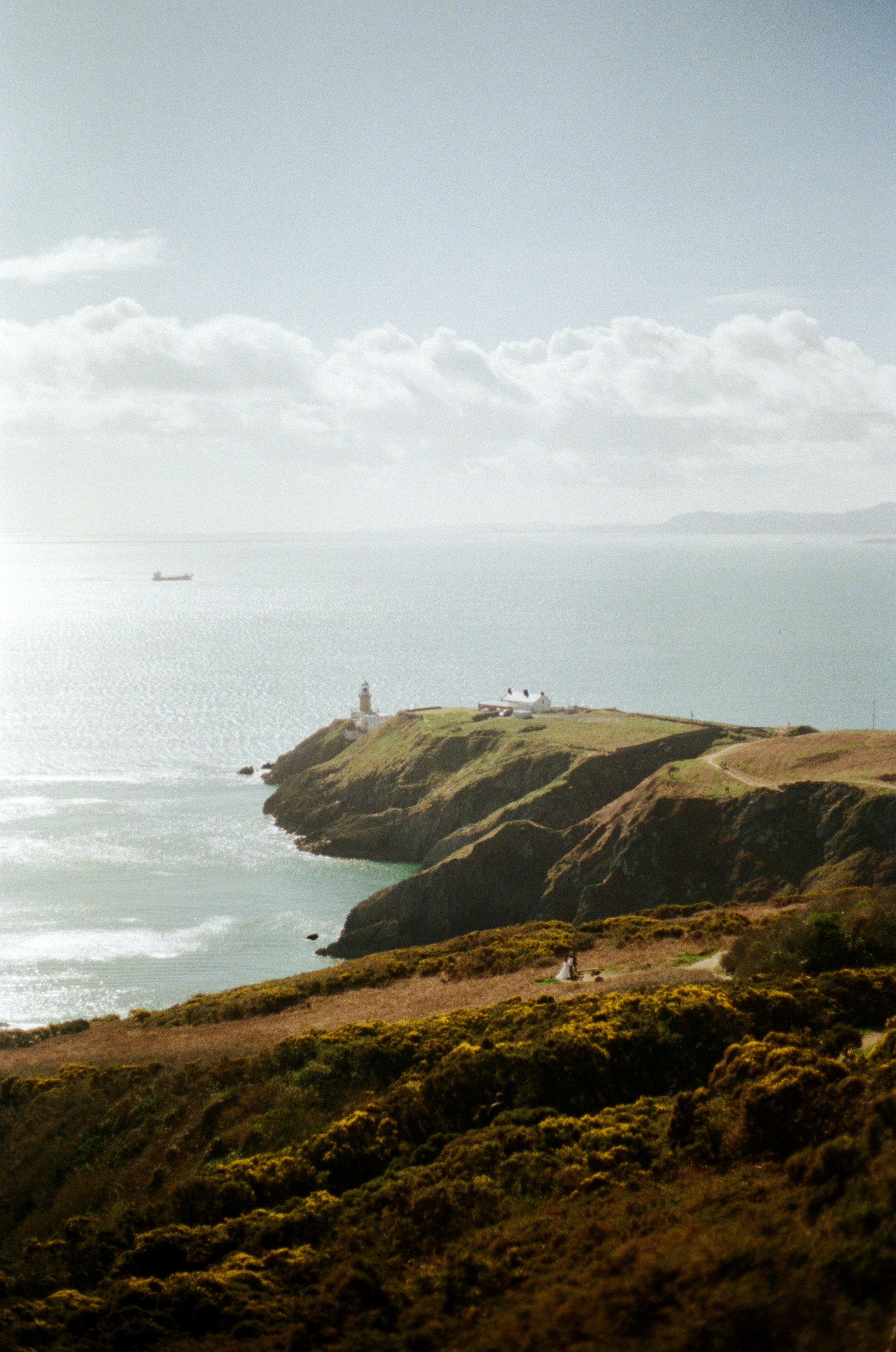 Lighthouse on a grassy cliff overlooking the ocean
