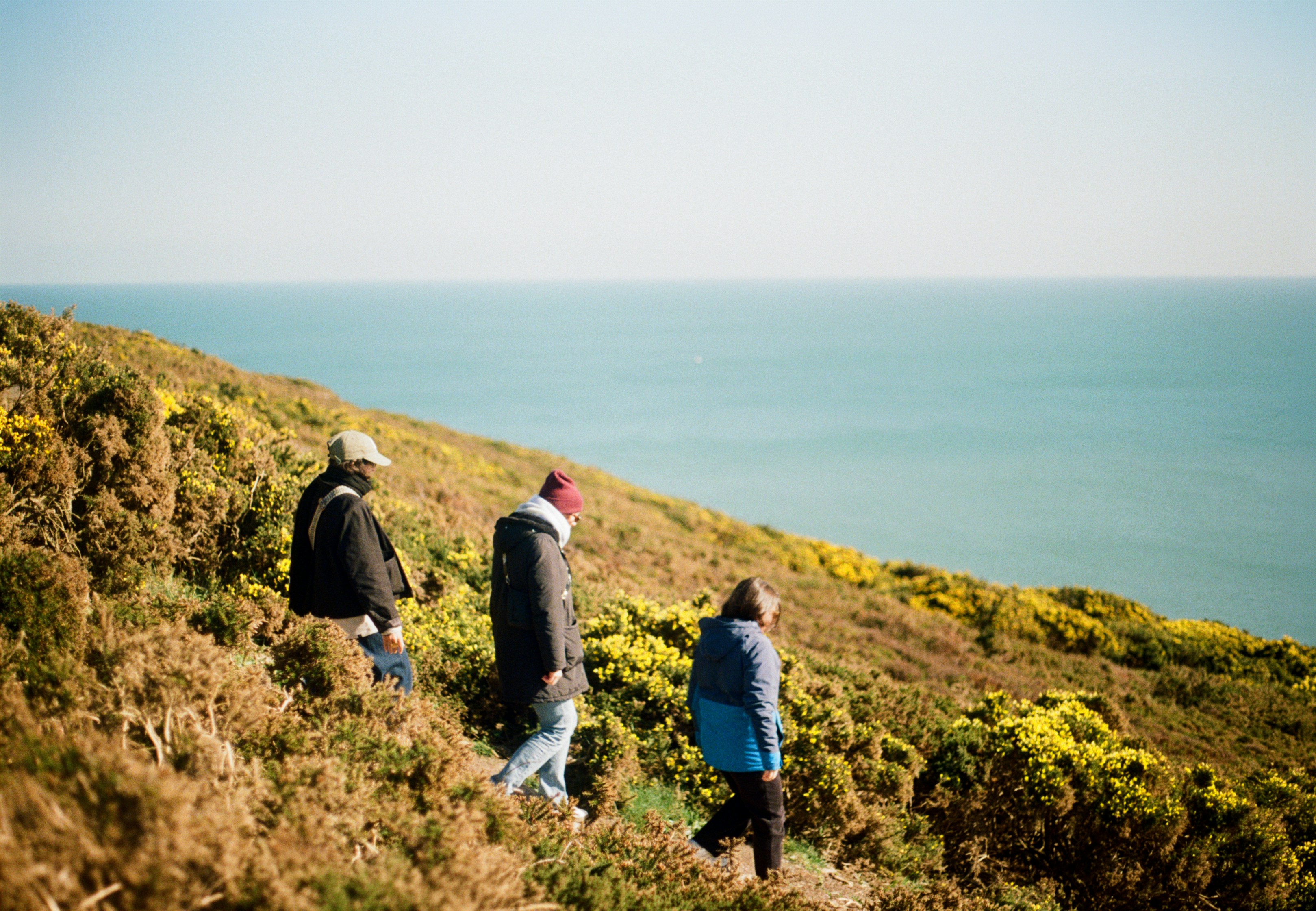 Three people hiking on a coastal path