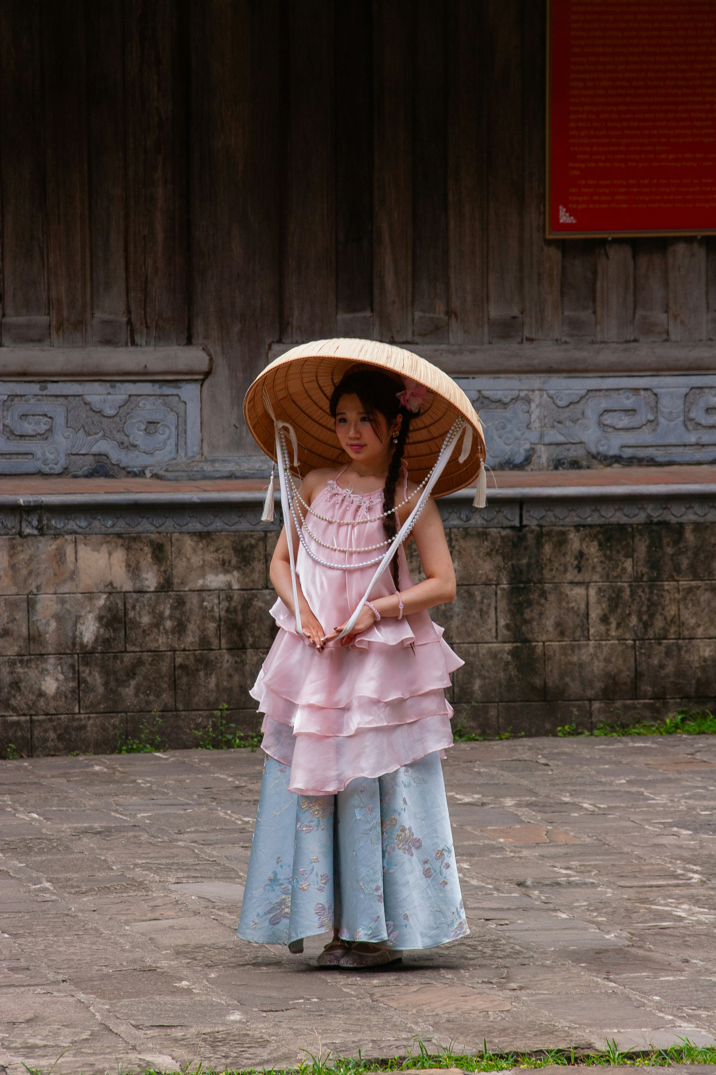 Young woman in traditional asian conical hat and dress.