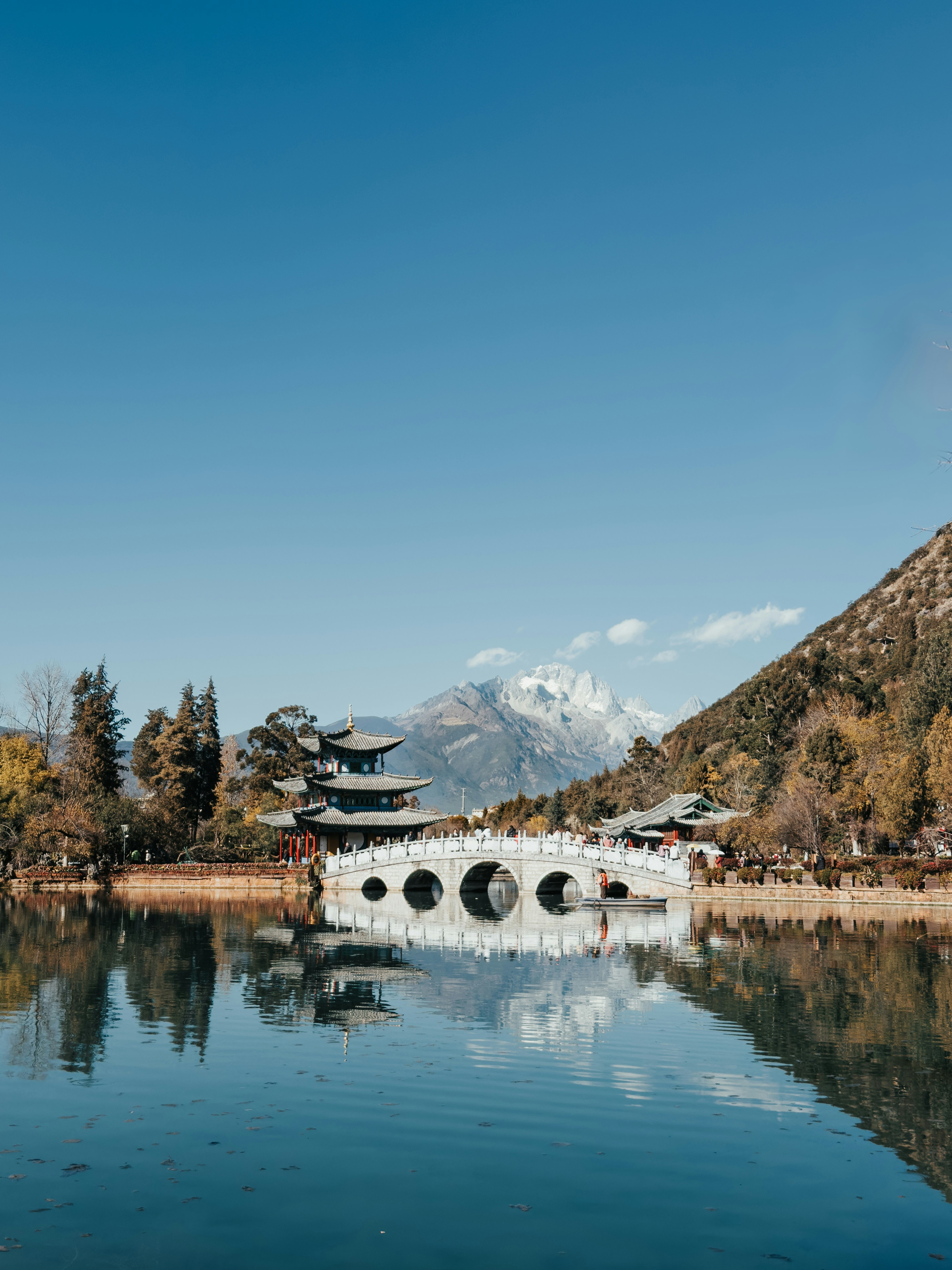Puente y pagoda tradicionales chinos reflejados en el agua.