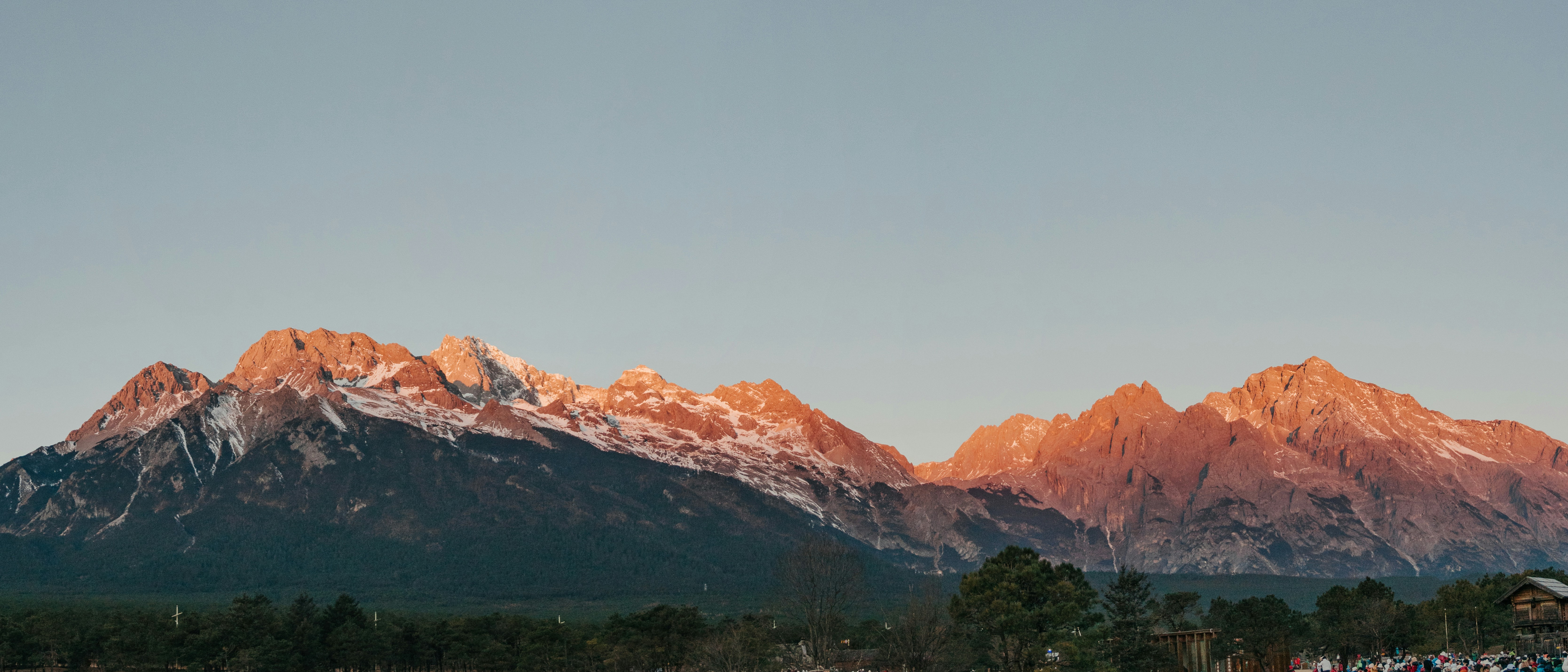 Montañas nevadas iluminadas por la luz dorada del atardecer.