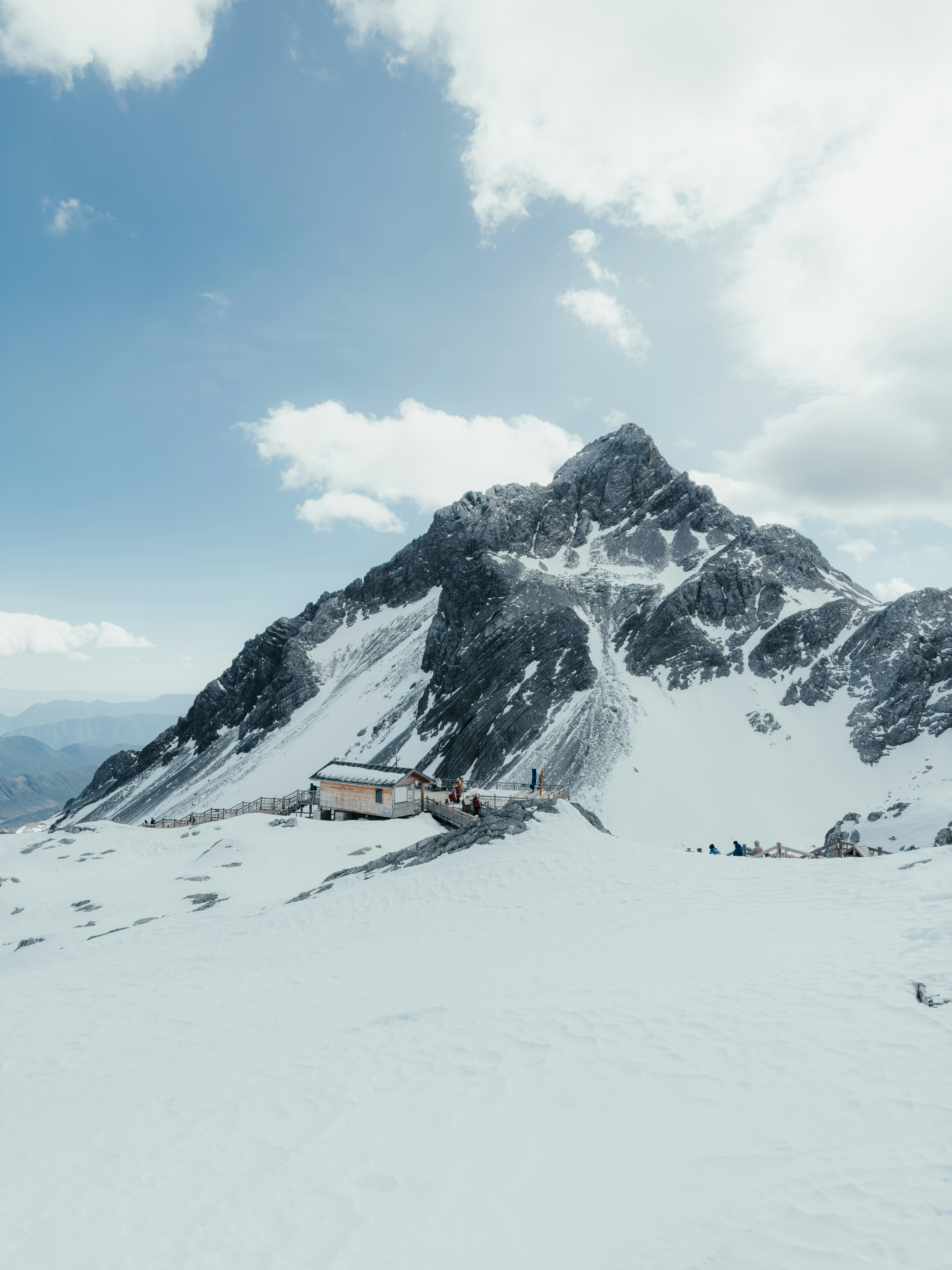 Pico nevado con un pequeño edificio