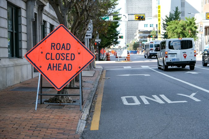 A road closed ahead sign on a city street, a reminder to plan detours through downtown Las Vegas while Charleston storm drain work continues