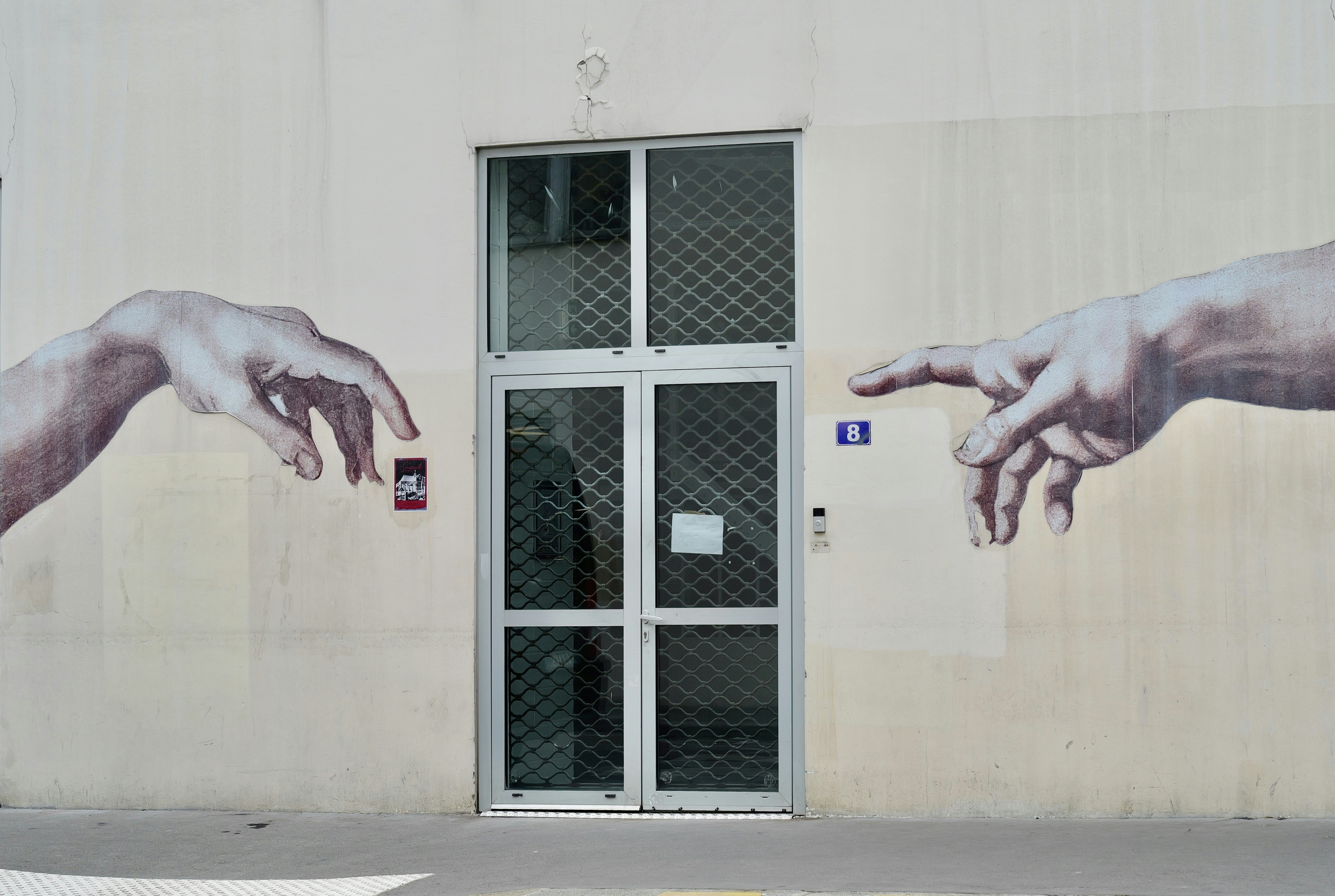 Two hands reaching towards each other on wall