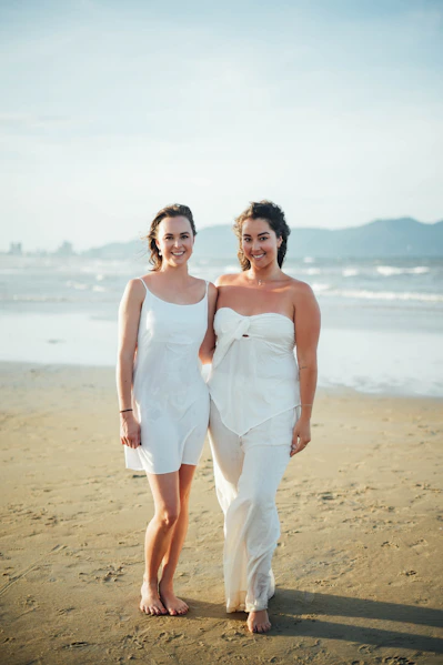 Two women in white on a sandy beach