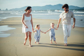 Family walking on a beach at sunset