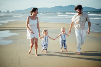 Family walking on a beach at sunset