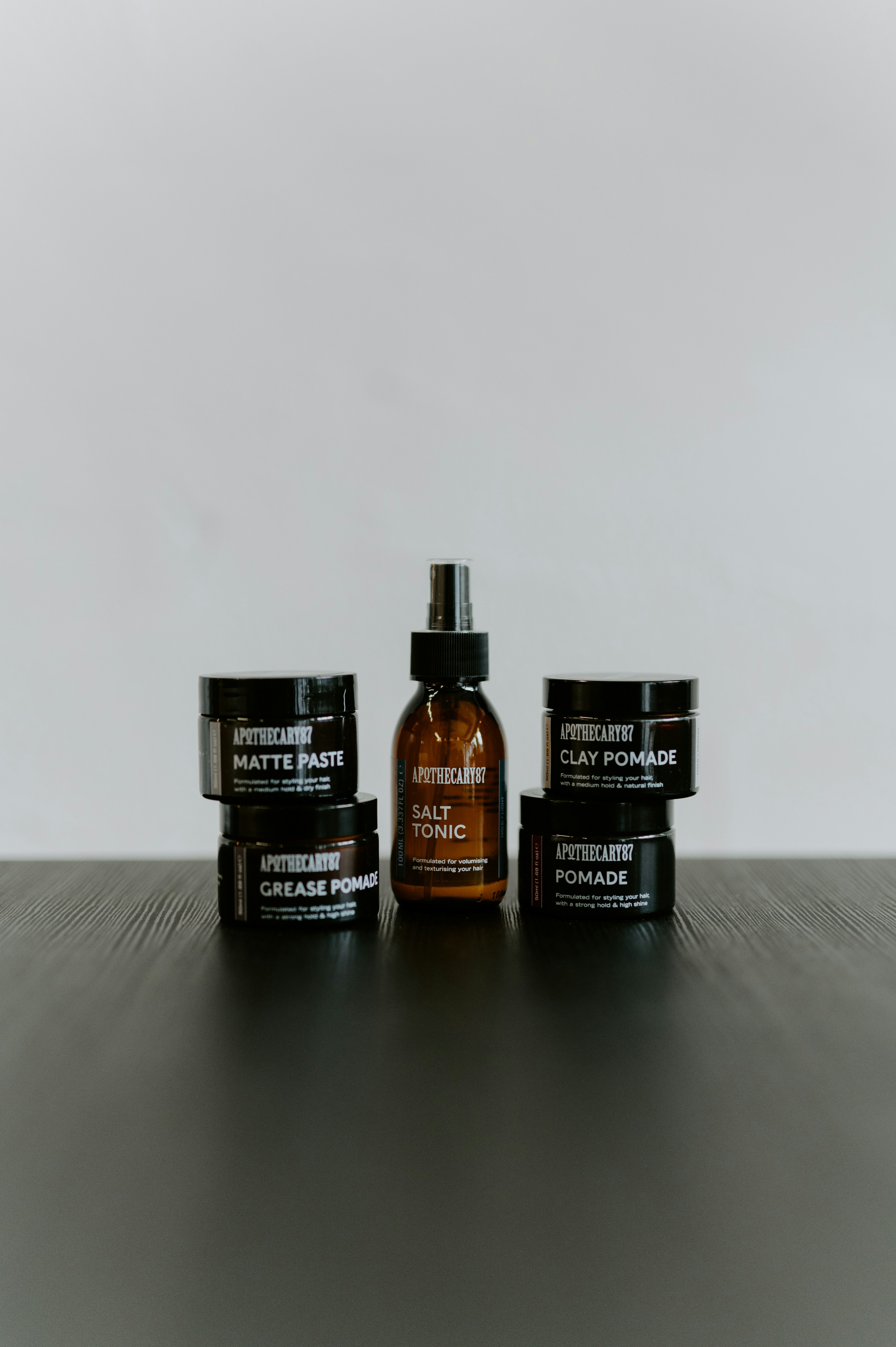 Hair styling products including pomade, paste, and tonic.