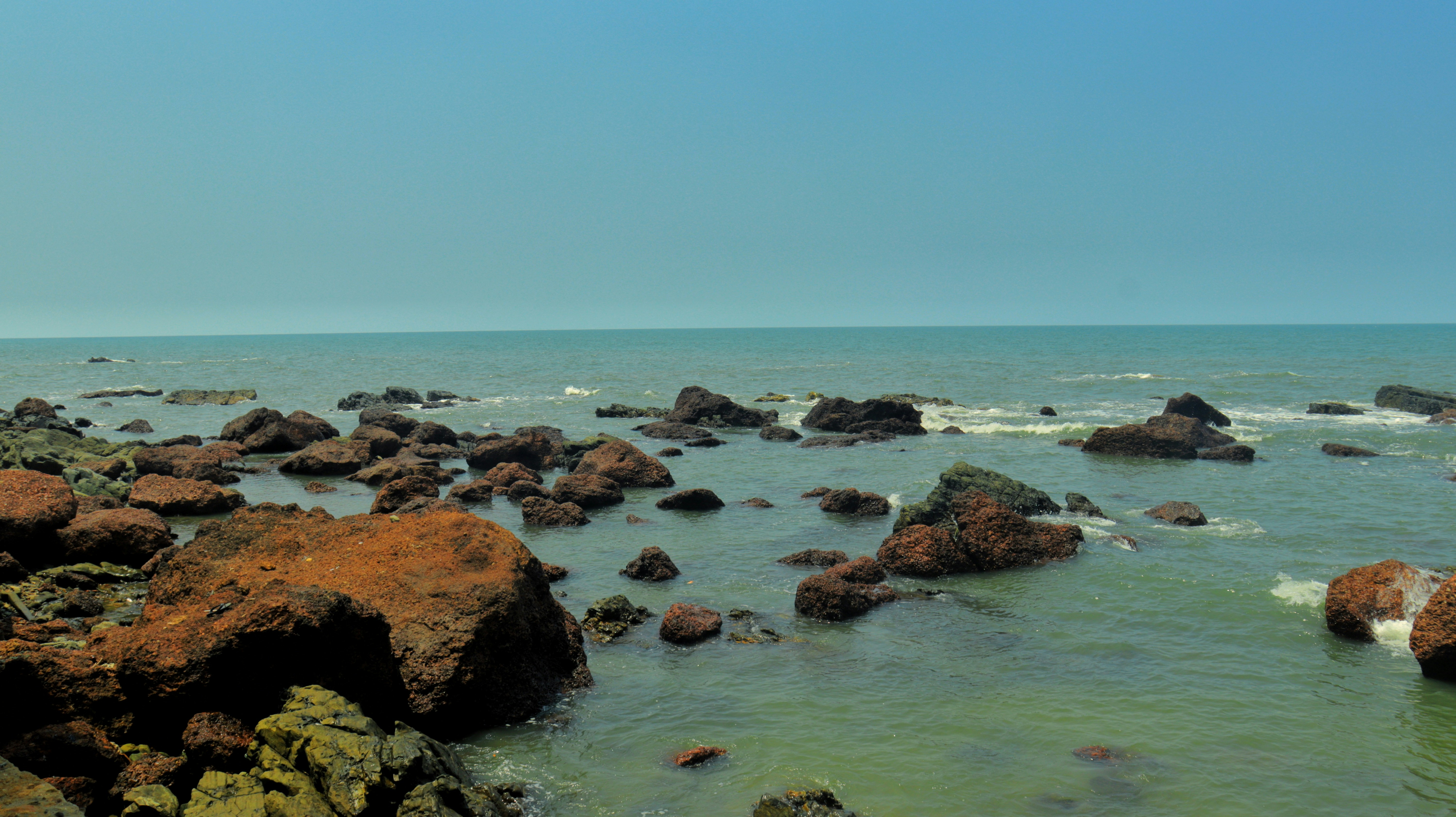 Rocky coastline with calm ocean water under a clear sky