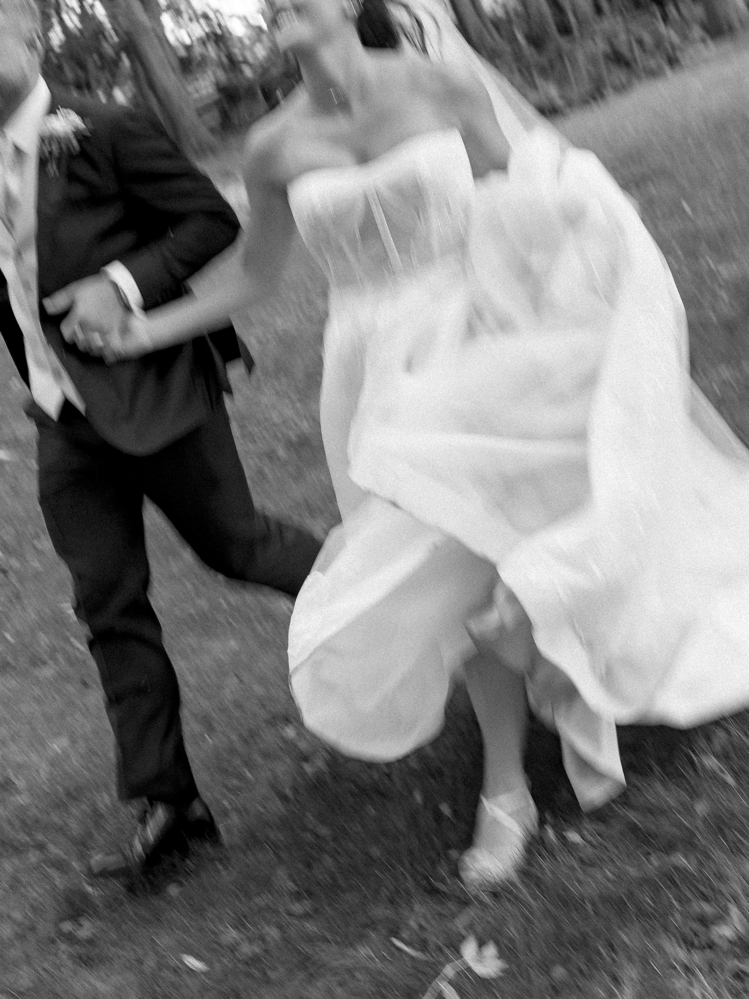 Bride and groom running together outdoors