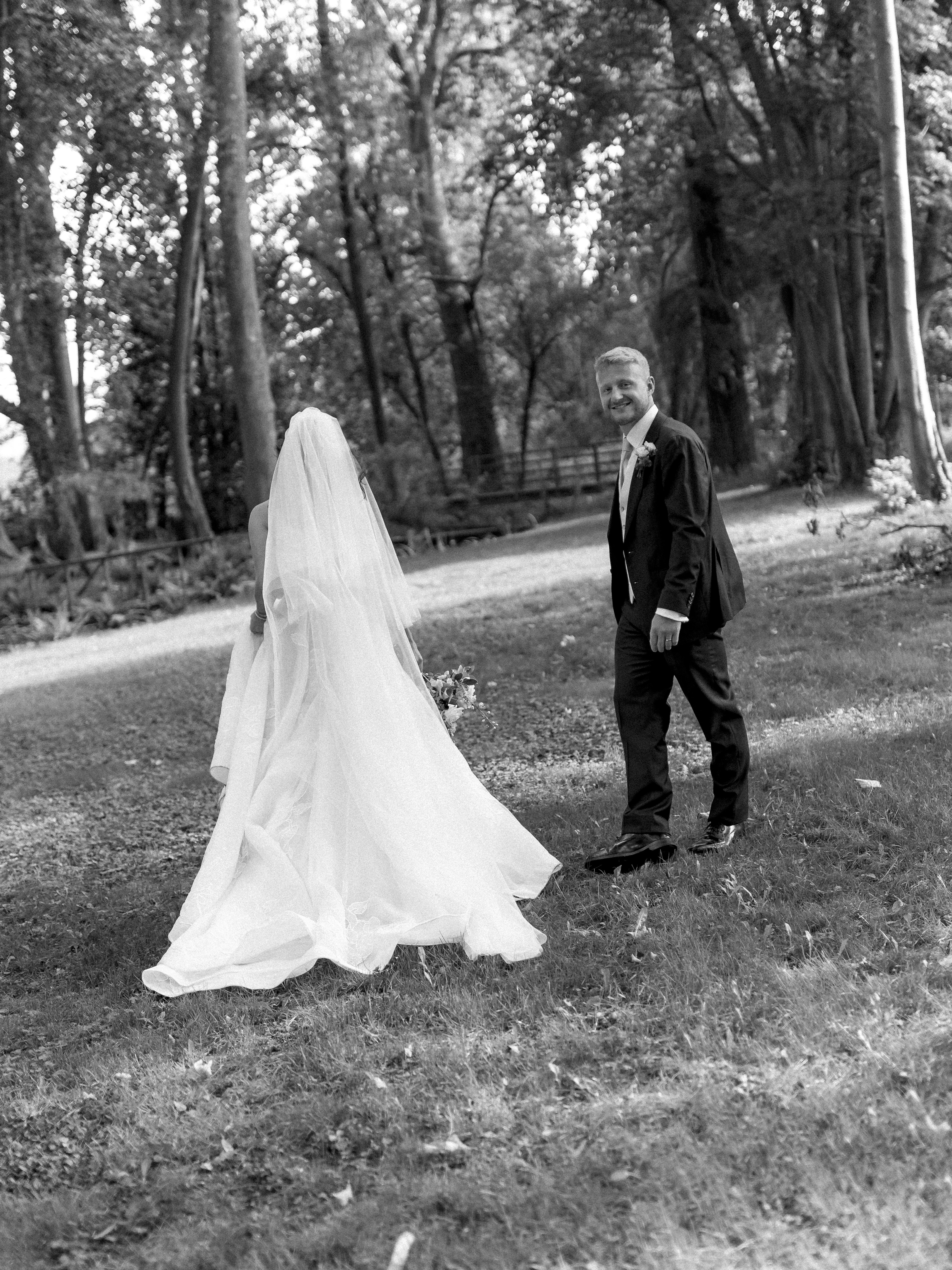 Groom watches bride walk away in forest