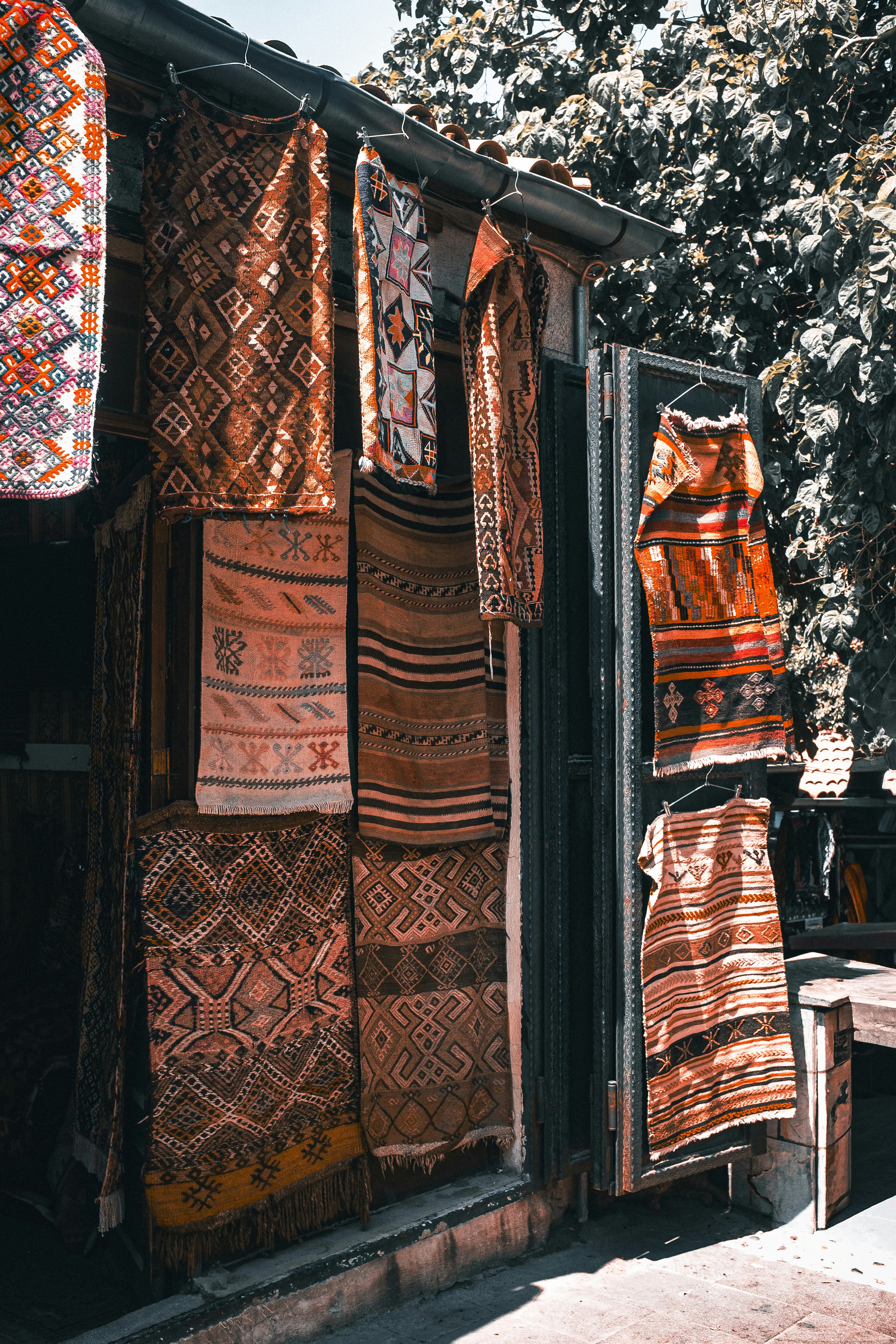 Textilien mit geometrischen Mustern hängen vor einem Laden.