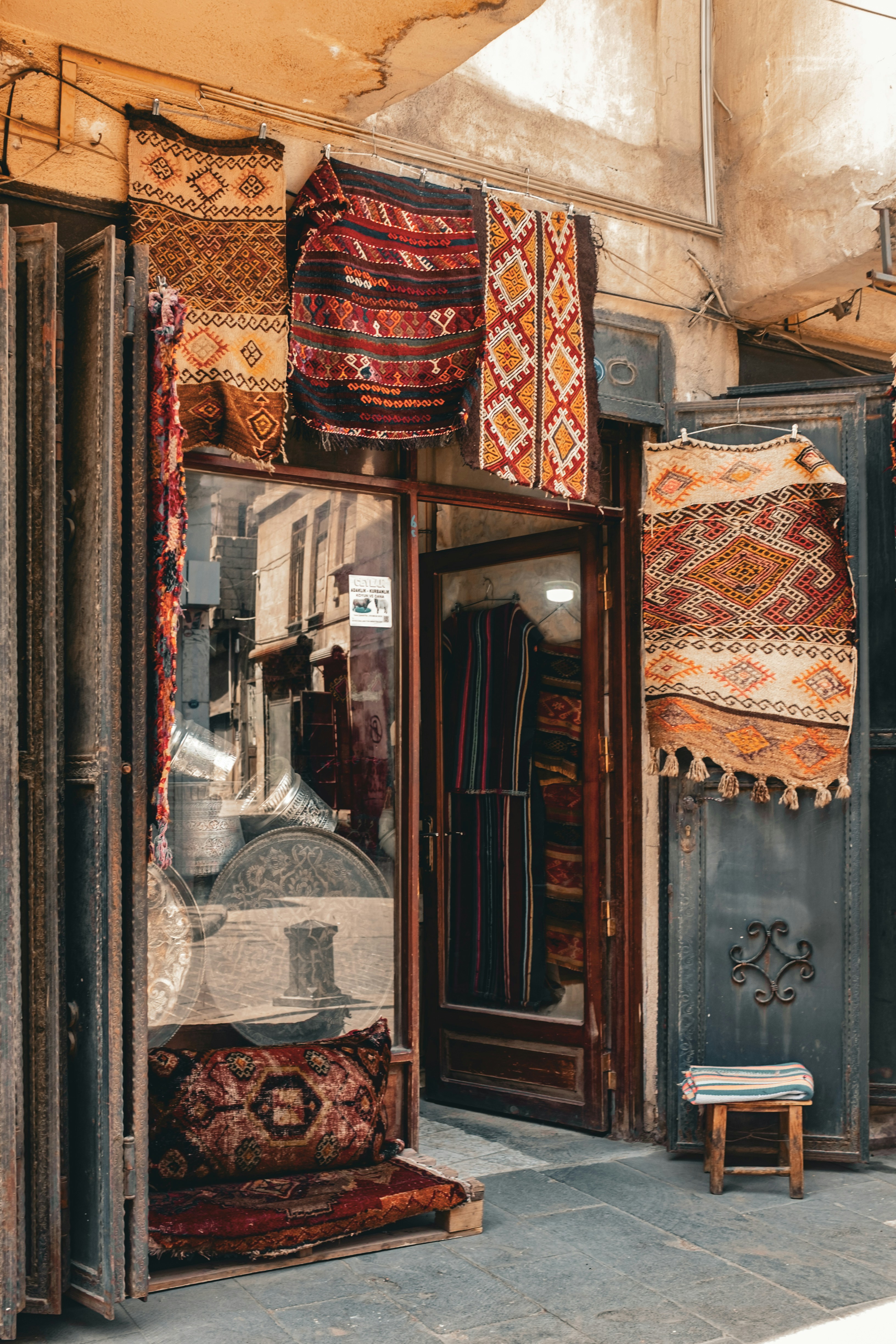 Bunte Teppiche, die vor einem Ladeneingang ausgestellt sind.