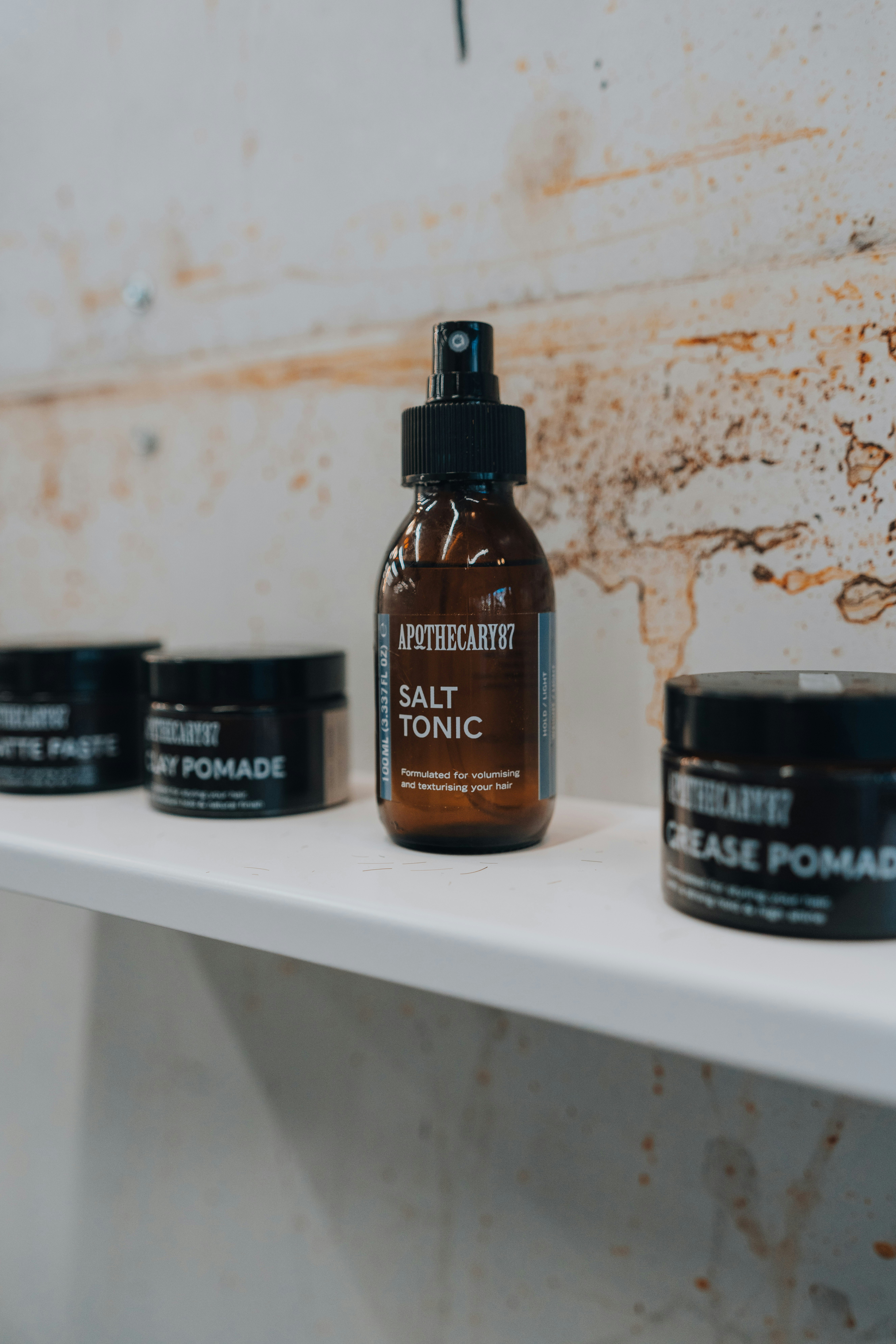 Apothecary salt tonic and pomades on a shelf.