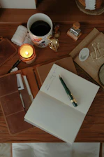 A cozy desk scene with a lit candle and coffee