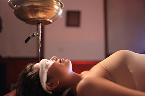 Woman receiving oil treatment on her forehead