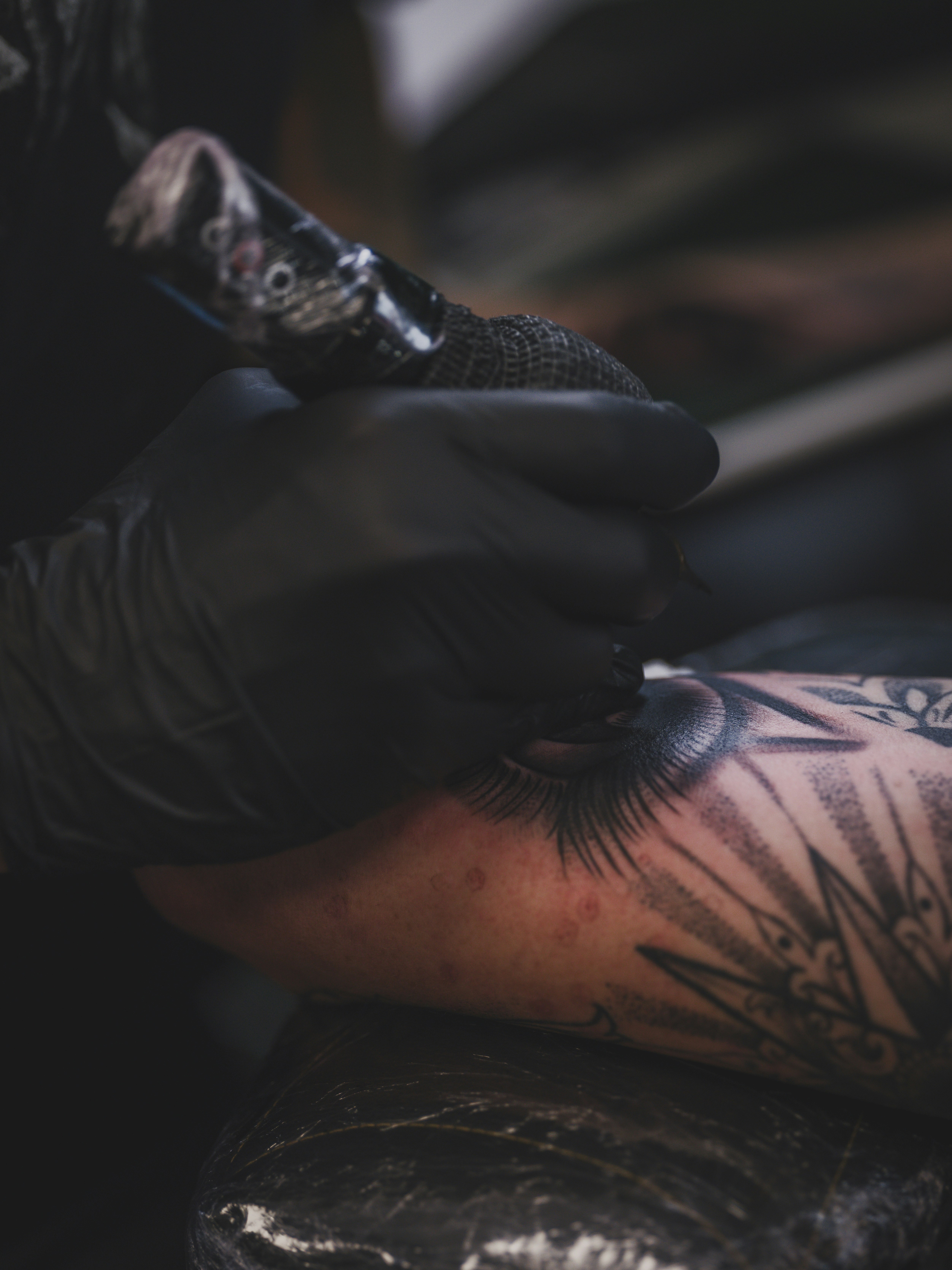 Tattoo artist working on a client's arm