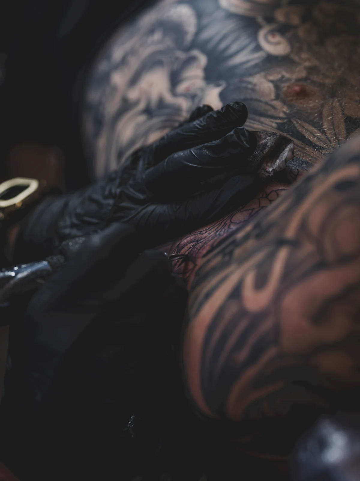 An artist working on an intricate arm design.