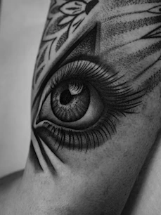 Detailed black and white tattoo of an eye