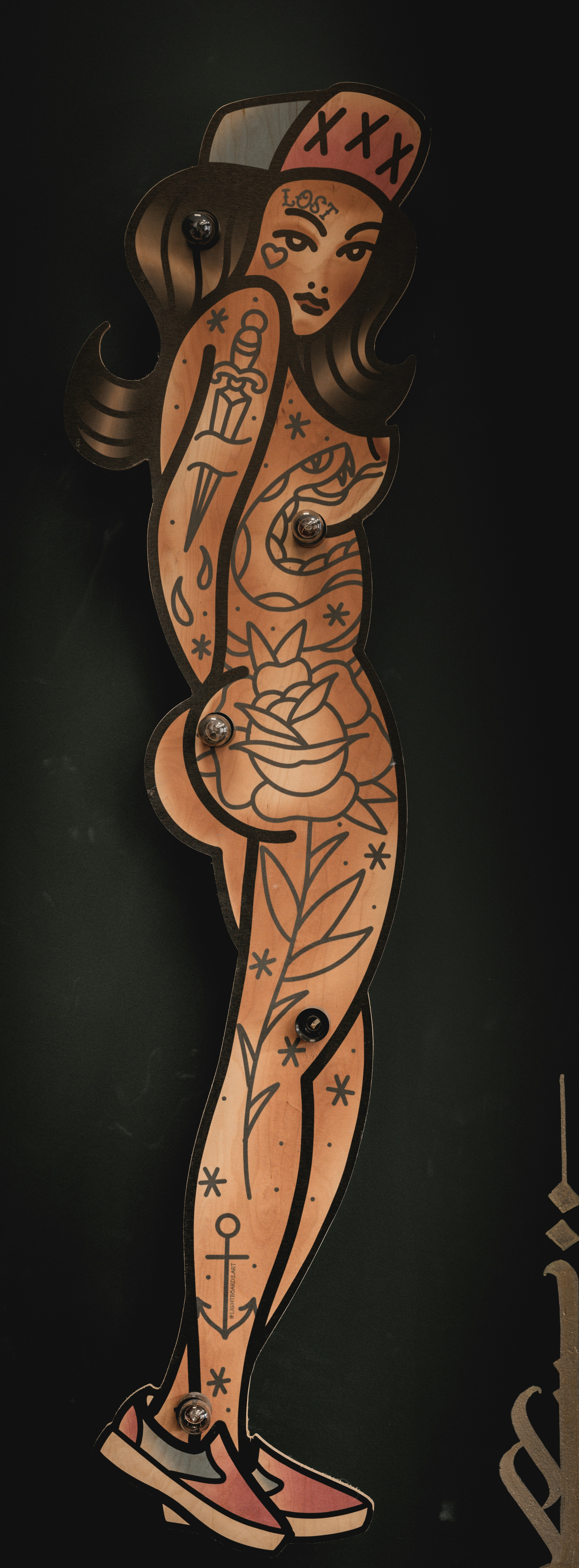 Tattooed woman wearing a backwards cap and sneakers.