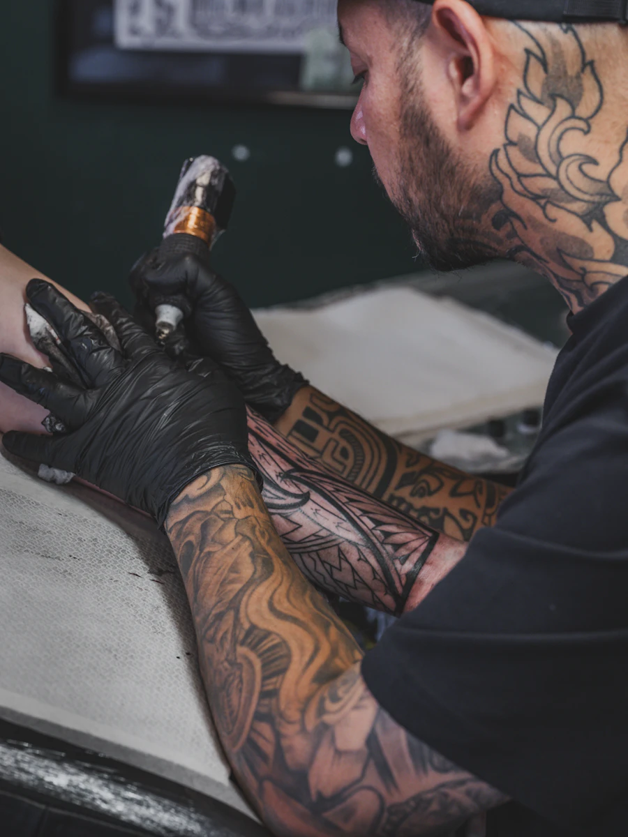 Teo working on a detailed sleeve on a client's upper arm