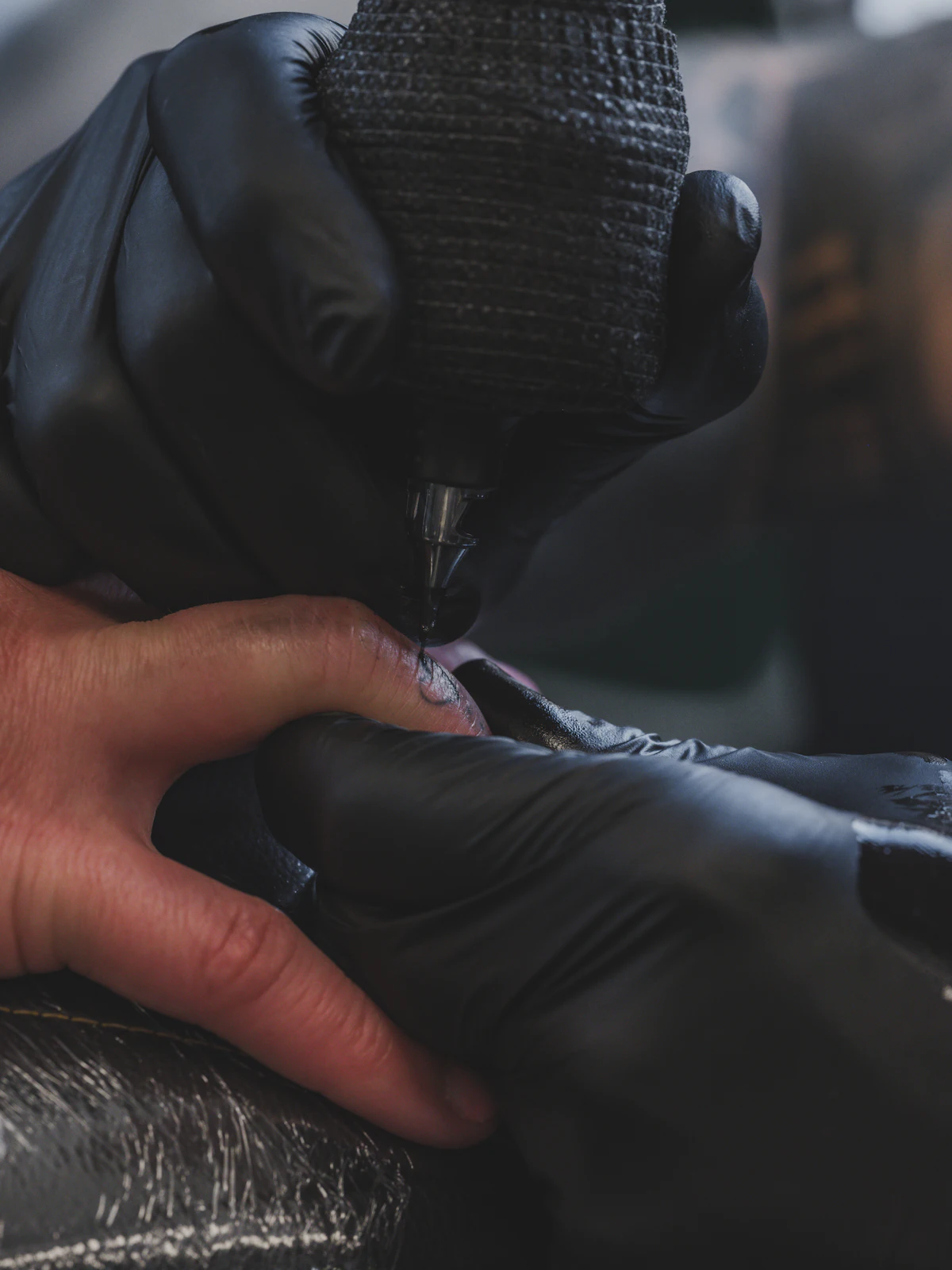 A tattoo machine applying ink at close range.